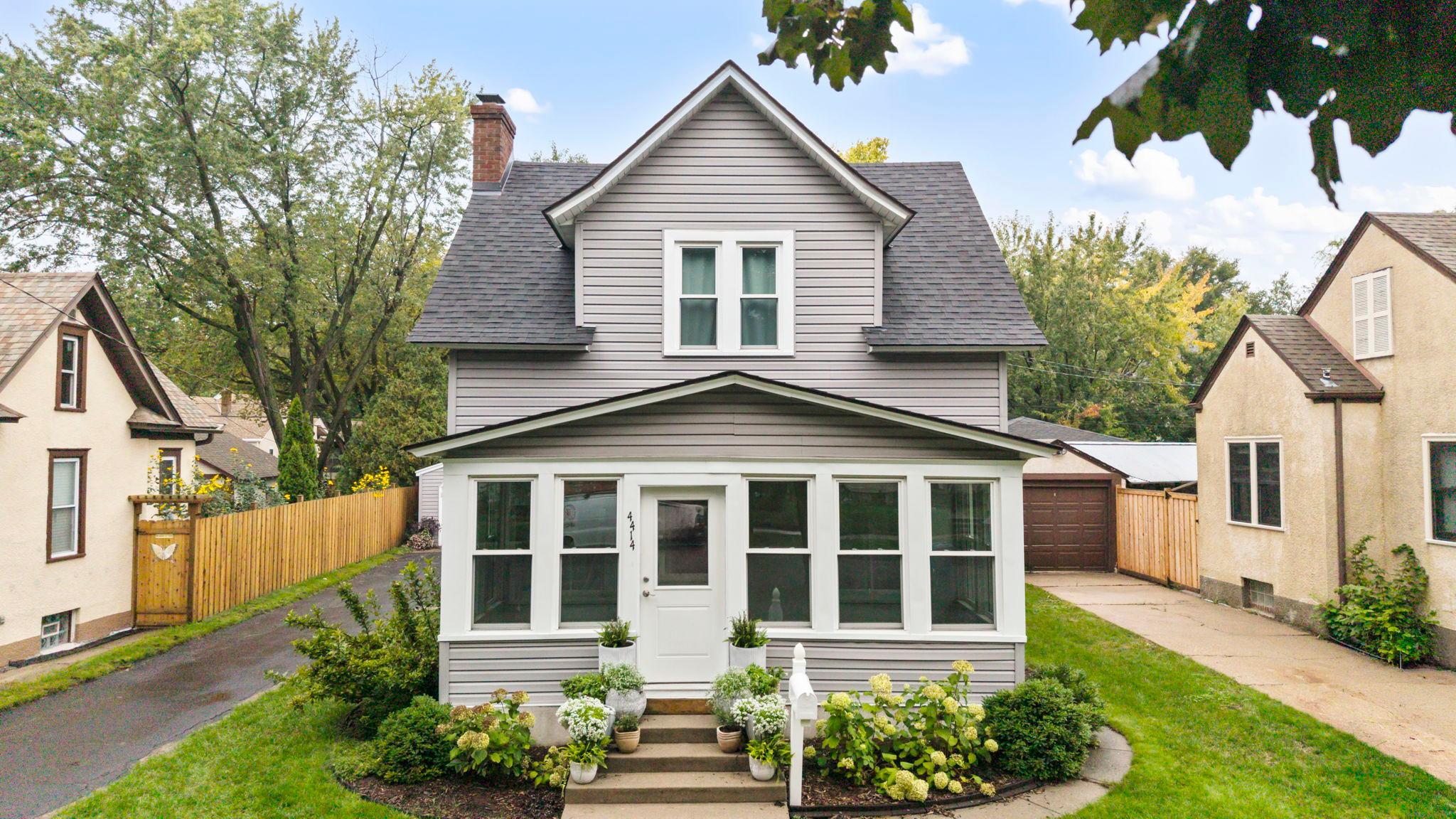 Walkable, welcoming and full of personality, this Southeast Minneapolis home puts the Mississippi River, Hiawatha Elementary, trails, parks, shops, restaurants and transit close at hand.Inside, bright spaces pair with hardwood floors, updated in 2021. A decorative fireplace adds character to the living room, while the fully remodeled kitchen (2024) features new appliances, soft-close cabinetry and a beautiful backsplash.The connected dining room and three-season sunroom create inviting spots for morning coffee or enjoying the tree-lined neighborhood.The main-level family room offers dual closets and a convenient Samsung washer/dryer, with the flexibility to use the space as additional main-level third bedroom or primary instead!Upstairs, two bedrooms feature walk-in closets and new carpet (2021), with a remodeled bathroom with rain-shower nearby (2022).Outside, a paver patio, firepit and privacy fence (2024) create inviting gathering spaces. A standout bonus: oversized detached two-car garage with a new door (2026) and driveway, offering rare off-street parking! Seller is offering a $5,000 flooring credit at closing to update the floors to your taste.
