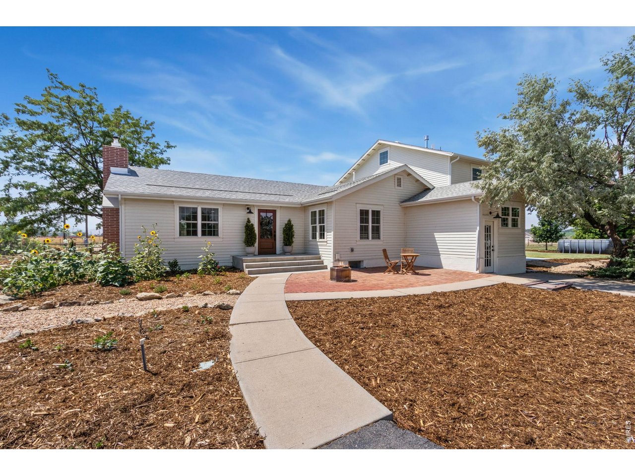This renovated farmhouse offers a fresh opportunity on 2 acres. The home blends original farmhouse character with extensive modern updates and flexible living space. The upstairs primary suite provides a spacious retreat, while a main-level bedroom with ensuite bath offers flexibility for guests, multigenerational living, or a home office. The renovated kitchen features custom European-style cabinetry, with updated bathrooms, flooring, paint, electrical, plumbing, tankless water heater, furnace/AC units, and new appliances. Two full-size washer and dryer sets add convenience. Outside, you'll find new siding, roof, windows, doors, patios, and exterior paint, along with owned solar panels and a Tesla EV charger. The 2-acre property also includes a barn, studio, non-potable water access for irrigation or animals, garden and animal space, and an extensive custom irrigation system designed with water conservation in mind. With room for outdoor projects, gardening, animals, entertaining, or simply enjoying the acreage, this property offers a rural setting with convenient access to Fort Collins, Wellington, Laramie, and Cheyenne. Basic 1-year First American Home Warranty is being offered by the Seller's Agent.