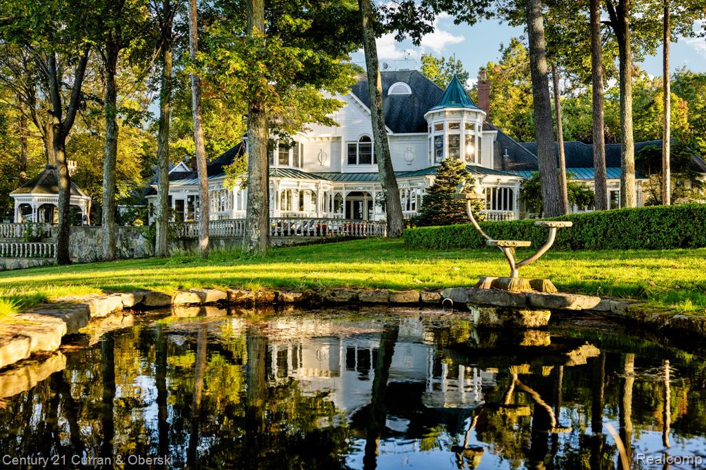As soon as the gate opens, the quarter-mile driveway leads you into a place so enchanted, some don’t even believe it.  Tucked within 14.1 private wooded acres and surrounded by 1,500+ feet of direct Mullett Lake frontage, Red Pine Point stands among Northern Michigan’s most remarkable lakefront estates. The Victorian-inspired main residence offers 15,970 sq. ft. of living space and over 18,000 total finished sq. ft., including in-law and caretaker quarters, multiple garages, and a lakeside gazebo. 
Built with exceptional craftsmanship, the home features hand-carved millwork, rare Bird’s-eye maple paneling, coffered ceilings, marble fireplaces, and tin-inlaid details. The 1,400-sq. ft. great room centers on a marble fireplace flanked by hand-carved Caryatids with panoramic lake views. A chef’s-grade kitchen offers commercial appliances, dual islands, a walk in pantry and custom cabinetry adjoining both formal and casual dining areas. Additional highlights include an exquisite Library and billiards room, a media room, and wet bar with marble counters and nostalgic ice-cream parlor. The home provides 10 bedrooms and 13 baths, including a primary suite with private veranda, office, and spa-style bath. Structural features include radiant in-floor heat in various places of the home, heated quarter-mile driveway and walkways, attached four-car garage, and multiple auxiliary garages. Outdoor amenities feature stone terraces with balustrades, 131-ft veranda, 75-ft covered lakeside porch, multiple fire pits, manicured walking paths, and a lakeside gazebo with full bath, sitting area, spiral loft, and outdoor hearth. Located along Michigan’s Inland Waterway with boat access to Lake Huron and Mackinac , Red Pine Point offers extraordinary craftsmanship, privacy, and accessibility.