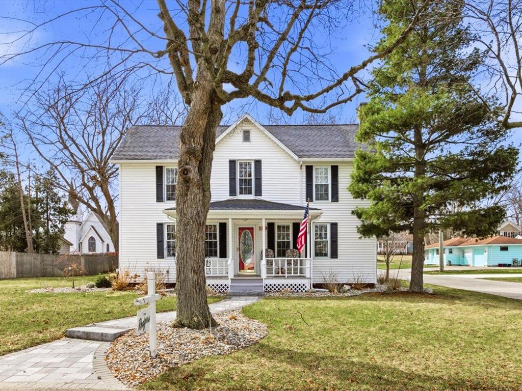 Goldilocks came in and said ''Ah, now this one is just right.'' With four spacious bedrooms there is plenty of room for all. You can host and prepare great meals in the expansive and updated eat-in kitchen. Enjoy chilly evenings curled up in front of the fireplace and summer evenings on the newer deck through the slider door off the living room. In-ground sprinklers keep your nicely landscaped, oversized yard lush with ease. A decent chunk of it is also fenced for privacy and quiet enjoyment.  The heated garage is perfect for tinkerers and hobbyists and contains the third full bath for when you have a full house. Just off the breezeway is a nice sized laundry room, perfect for kicking off flip flops and storing coolers. Only a block and a half from the beachfront park and marina and a stone's throw from the farmers market, you can enjoy small lake town life to the fullest either seasonally or year-round. Very motivated seller. Bring all offers and don't miss out on this amazing home!