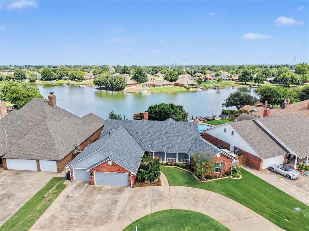 Rare waterfront living in NW OKC, minutes from Trader Joe’s, NW Expressway, and the Kilpatrick Turnpike. The home has a circle drive and covered front porch, and the landscaped backyard with mature trees leads to your own dock. Enjoy sunrises over the lake, sunsets from the porch, and your kayak or paddleboat any time.This 3 bed, 2.5 bath home offers nearly 3,000 sq ft with rich wood floors, a formal dining room, and a living room with a lighted wet bar that closes off when not in use. A double-sided brick fireplace is shared with a gallery of floor-to-ceiling windows overlooking the water. The kitchen has granite counters, stainless appliances, a gas cooktop, an island, a skylight, and lake views from the sink.The primary suite, bath, closet, and laundry were remodeled to the studs. French doors open toward the lake, and the bath features a freestanding soaking tub, a glass walk-in shower with a matte black multi-head rain system, a dual sink quartz vanity, and custom cabinetry. A walk-in closet connects to an oversized laundry and craft room with built-in cabinets, an ironing board, and a utility sink. There are two more bedrooms, one with built-in bookcases and a desk.Major updates in addition to the remodel include a new roof (2023), new windows, two new water heaters, shutters, exterior lighting, + wired security cameras. If you’ve been searching for a home that combines everyday convenience with a unique waterfront lifestyle, this is the one to move quickly on!