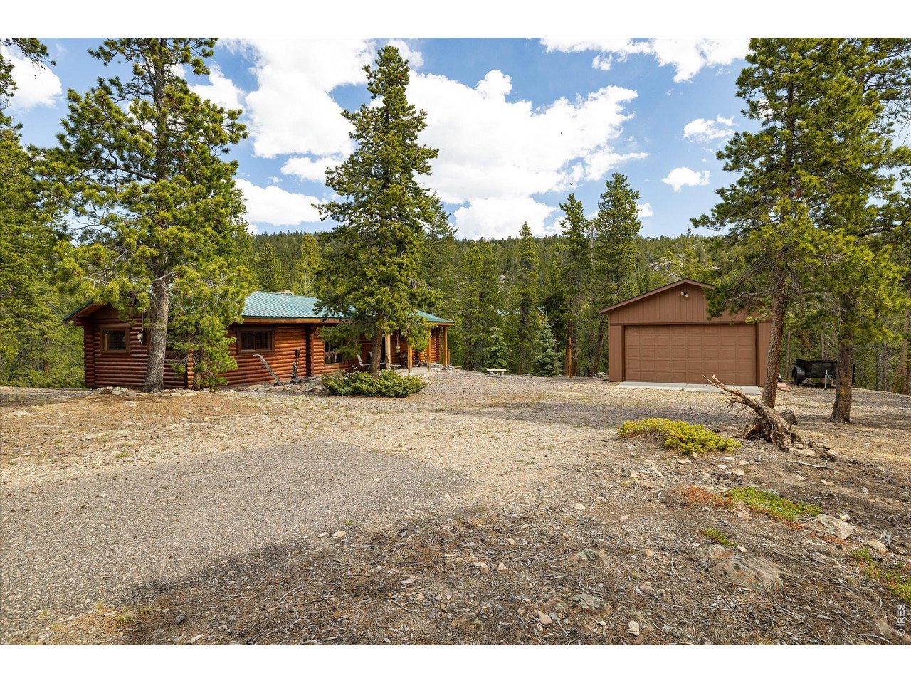 Colorado Mountain Home thoughtfully updated and impeccably maintained. A perfect blend of rustic character and modern comfort on over an acre of mostly level land that gently slopes to a meandering stream. Enjoy peaceful living with mountain views. Inside, the open floor plan is centered around a moss rock-surround pellet stove creating a cozy and inviting atmosphere. The fully remodeled kitchen features new cabinetry, custom coffee bar and thoughtfully designed built-ins. Waterproof engineered plank flooring extends throughout the living room, dining area, kitchen and bathroom, adding beauty and durability. The 3/4 bath has been remodeled and includes a dedicated wallboard heater for added comfort. Additional improvements include closed-cell spray foam insulation, enhancing energy efficiency year-round. Outdoor living is equally impressive with a spacious new wraparound deck perfect for relaxing or entertaining while enjoying the surrounding natural beauty and abundant wildlife passing by. A newer 400 sq ft detached garage is insulated with (R-30) fiberglass batts and features a 240-volt/30-amp plug to power a farmhouse heater for the entire garage during the winter. Water, sewer and electric service are in place to support two RV sites - ideal for guests or additional recreational use. Golden Gate Canyon State Park is just 10 minutes away, with Boulder and Golden each a 30-minute drive. Groceries and fine dining are only 20 minutes away. This wonderful mountain home offers comfort and modern upgrades in a truly beautiful and peaceful setting. Come live where you play!