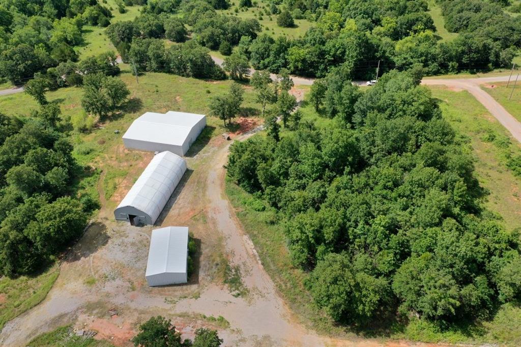 NESTLED JUST EAST OF LAKE THUNDERBIRD, THIS EXPANSIVE 2 4.98 ACRE PROPERTY, (ONE ADDRESS IS 2415 AND IS A COMMERCIAL PROPERTY & 2445 IS RESIDENTIAL) CONVENIENTLY LOCATED OFF HIGHWAY 9, OFFERS A PERFECT BLEND OF RURAL TRANQUILITY AND LIMITLESS POTENTIAL. COMPRISED OF TWO ADJOINING TRACTS, THIS LAND IS BEING SOLD TOGETHER AND IS IDEAL FOR A VARIETY OF USES, FROM AGRICULTURAL TO COMMERCIAL VENTURES OR A PRIVATE RETREAT.
THE PROPERTY FEATURES A SPACIOUS 1000 SQUARE FOOT INSULATED BUILDING ( PLUMBED FOR A BATHROOM AND HAS SEPARATED ROOMS SO COULD BE TURNED INTO AN APARTMENT) & A LARGER 3000 SQUARE FOOT INSULATED BUILDING, OFFERING AMPLE SPACE FOR STORAGE, BUSINESS, OR PERSONAL USE. ADDITIONALLY, THERE WAS A STATE OF THE ART FULLY AUTOMATED GREENHOUSE, PERFECT FOR AGRICULTURAL ENDEAVORS OR HORTICULTURAL PROJECTS.
A PICTURESQUE POND ADDS TO THE NATURAL CHARM OF THE PROPERTY WHICH IS ALSO DOTTED WITH TREES PROVIDING A SERENE ATMOSPHERE FOR BOTH RELAXATION AND WORK. THE LAND HAS BEEN WELL-MAINTAINED AND OFFERS A WEALTH OF IMPROVEMENTS, INCLUDING 2 1000 AMP TRANSFORMERS, ENSURING RELIABLE ENERGY FOR LARGE SCALE OPERATIONS. THE WELL IS ANOTHER STAND OUT FEATURE, PROVIDING AN IMPRESSIVE 200 GALONS PER MINUTE-IDEAL FOR IRRIGATION, FARMING, OR PERSONAL USE.
OTHER KEY FEATURES INCLUDE AN AEROBIC SEPTIC SYSTEM, A STORM SHELTER, AND A CONVENIENT CIRCLE DRIVEWAY, ENHANCING BOTH SAFETY AND ACCESSIBILITY. WITH NO CITY OR COUNTY ORDINANCES TO WORRY AABOUT, YOU HAVE THE FREEDOM TO CUSTOMIZE AND DEVELOP THE PROPERTY AS YOU SEE FIT, WHETHER FOR COMMERCIAL, AGRICULTURAL, OR RESIDENTIAL PURPOSES. THIS PROPERTY OFFERS A RAR COMBINATION OF LOCATION, IMPROVEMENTS, AND POSSIBILITIES, TRUELY AN INVESTMENT THAT CAN BE TAILORED TO MEET A WIDE RANGE OF NEEDS. WHETHER YOU'RE LOOKING TO EXPAND YOUR BUSINESS, START A FARM, OR CREATE A PEACEFUL RETREAT, THIS IS A MUST SEE PROPERTY.