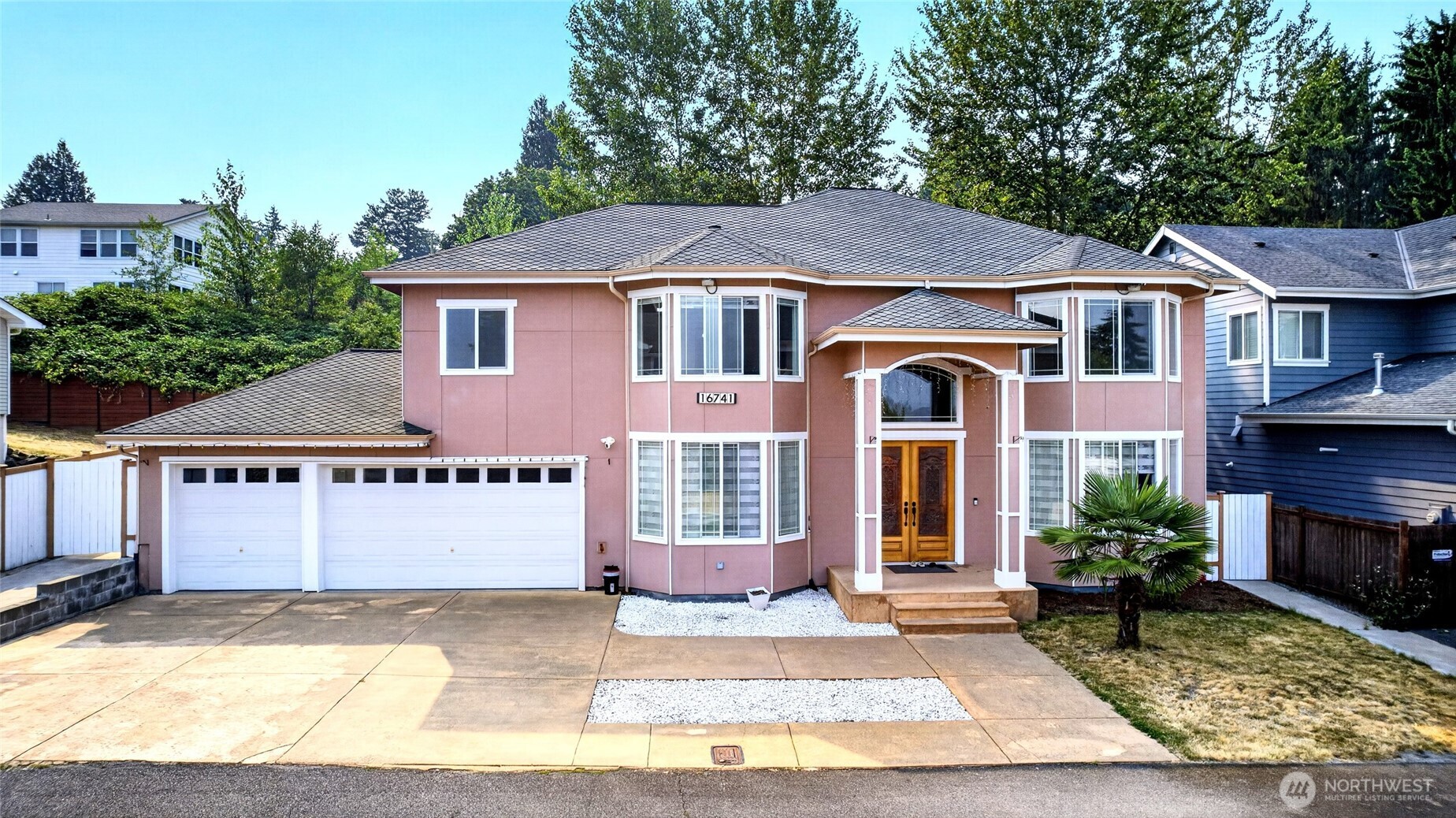 Welcome home to this beautifully crafted custom residence featuring 4 bedrooms and 4 private bathrooms. Step through custom double doors into an elegant interior with soaring ceilings, porcelain tile flooring, and radiant heat. The gourmet kitchen offers granite countertops, premium Bosch, KitchenAid, and LG appliances, soft-close cabinetry, and a large walk-in pantry. The spacious primary suite includes a walk-in closet and a 10-jet Jacuzzi tub. Additional highlights include central A/C, central vacuum, designer lighting, crystal chandeliers, a second full kitchen in the garage, a covered deck for entertaining, prayer room, large laundry, extra storage, fenced yard, no HOA, valley views, and, on clear days, views of Mount Rainier.