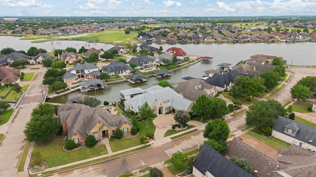 Back on the market! Due to the buyer's failure to perform, the sellers exercised their right to terminate.Experience refined lakefront living in this stunning waterfront home within Harbor Lakes Golf Club. Enter through iron doors into a thoughtfully designed residence featuring four generously sized bedrooms, 3.5 baths, a private office, game room, and media room, offering flexibility for entertaining, relaxing, and everyday living. At the heart of the home, the main living room features an impressive floor-to-ceiling stone fireplace that creates a warm and inviting atmosphere. The kitchen is equipped with stainless steel appliances, a large island with a prep sink, built-in microwave, warming drawer, and a spacious butler’s pantry, perfect for hosting guests or keeping daily life organized. The primary suite serves as a private retreat, featuring dual vanities, a jetted soaking tub, walk-in shower, and an oversized custom walk-in closet. Storage is abundant throughout the home, including a laundry room complete with cabinetry, a utility sink, and a built-in ironing board. Upstairs, you'll find an expansive game room and media room featuring additional cabinetry, a sink, and space for a refrigerator. The fourth bedroom offers access to a private balcony with peaceful views of the pool and lake, creating the perfect place to unwind. Outside, enjoy a resort-style backyard designed for entertaining and relaxation. The pool and spa overlook the water, while the private boat dock and open patio with a built-in grill and smoker make outdoor living effortless. Wrought-iron fencing with a lower safety panel keeps pets secure without obstructing the scenic lake views. Four separate rooms provide direct access to the outdoor living area, seamlessly connecting indoor and outdoor spaces. Additional highlights include a watercraft slip, spacious three-car garage, circle driveway, new flooring throughout the downstairs level, and a new upstairs AC unit installed in October 2025.