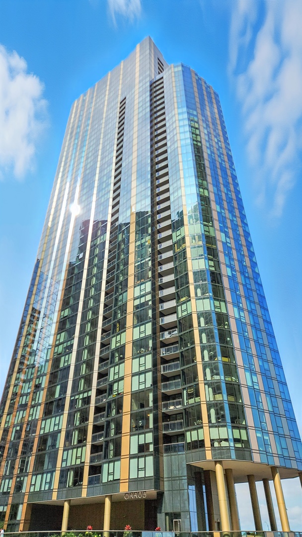 Stunning 1-bedroom, 1-bathroom condo on the 36th floor of the prestigious CIRRUS tower featuring floor-to-ceiling windows with captivating city skyline views. This 687 square foot home showcases wide-plank hardwood floors, custom Snaidero cabinetry, Dornbracht fixtures, and quartz countertops with beautiful tile backsplash throughout. The kitchen is equipped with high-end Gaggenau and Bosch appliances and soaring 9-foot ceilings enhance the open feel. In unit washer dryer installed in 2023.  CIRRUS offers over 48,000 square feet of resort-style amenities including state-of-the-art fitness center, indoor lap pool, 24-hour concierge service, and landscaped rooftop terraces. The 41st-floor chef's kitchen provides stunning Lake Michigan views along with outdoor pool areas, fire pits, and grilling stations. Additional amenities include work spaces, entertainment areas, pet facilities with dog run, and bike storage.  Prime Lakeshore East location provides walkable access to Millennium Park, Lakefront Trail, and downtown dining and entertainment. This move-in ready residence INCLUDES garage parking and is available fully furnished. Contact listing agent for furnished package details. Experience luxury living in one of Chicago's most desirable waterfront neighborhoods.