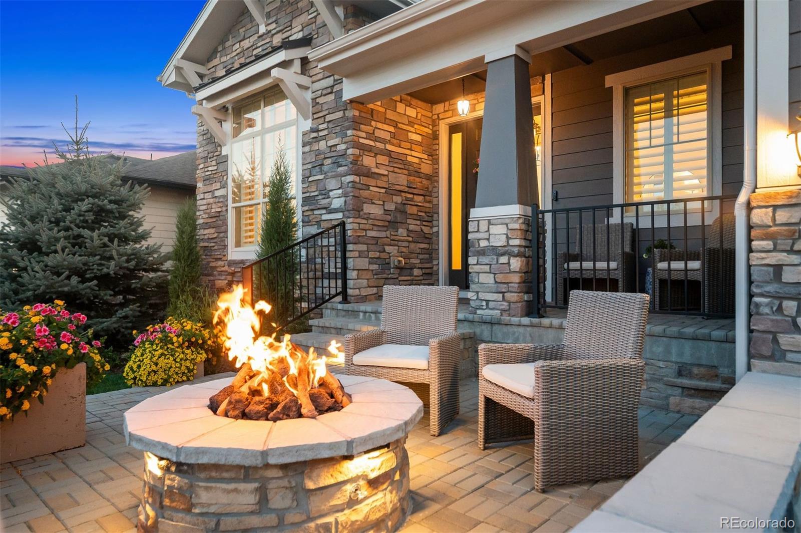 Welcome to elevated living at its finest. This former Toll Brothers Bancroft model home is located in the prestigious 55+ Hilltop at Inspiration community and showcases sweeping 180-degree mountain views. Perfectly positioned on a quiet cul-de-sac backing to a greenbelt and just minutes from the clubhouse, this home offers an exceptional blend of luxury, comfort, and ease. Professionally landscaped grounds, elegant exterior lighting, and thoughtfully designed outdoor spaces set the stage for refined Colorado living. Inside, the home offers 4,367 square feet of beautifully finished living space with 10-foot ceilings, engineered hardwood flooring, and floor-to-ceiling stacking glass doors that frame the breathtaking mountain backdrop. The home is located on a  quiet cul-de-sac close to the community clubhouse. Fully owned solar panels provide zero electric cost, and recent major system updates include a new roof and new furnace, along with a tankless hot water heater equipped with a humidifier for year-round comfort. The kitchen features upgraded appliances designed for both everyday living and entertaining, including a Miele dishwasher and an upgraded stove and grill. Shutters and motorized shades are installed throughout the home, adding both style and convenience. The epoxy-coated garage includes an electric vehicle charging plug, completing the home’s modern, efficiency-focused upgrades. The professionally finished basement is ideal for entertaining and gathering, featuring a TV and pool table area with the pool table included, a wet bar with sink and refrigerator, oversized sliding doors that open to the entertainment area, and a versatile bonus craft or work room. Outdoor living is equally impressive, with exceptional spaces designed for year-round enjoyment. Highlights include built-in patio heaters and a front-yard stone patio with fireplace making it the perfect spot to take in Colorado’s stunning sunsets.