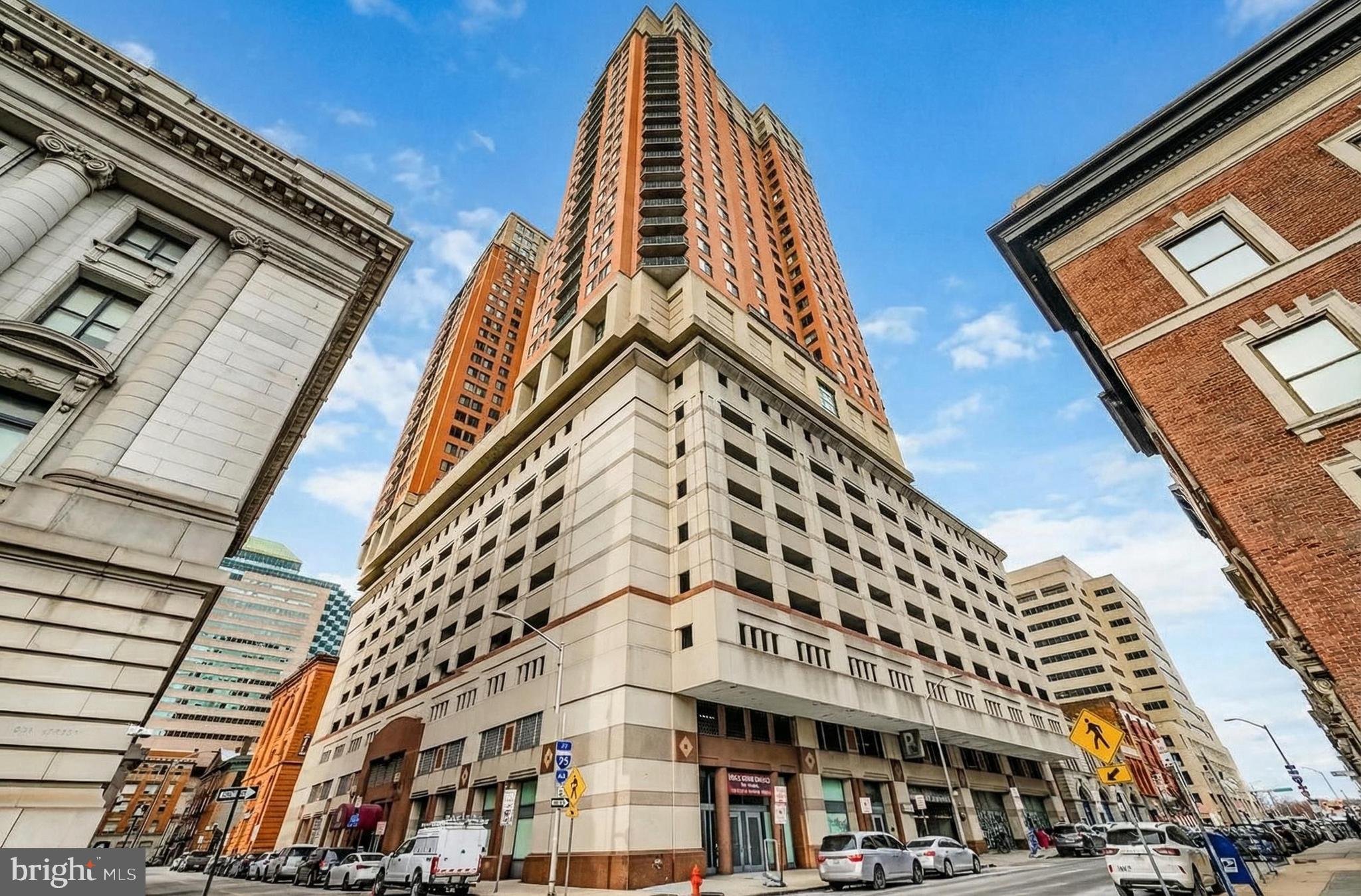 You’ll love this condo! The seller loved living here but has relocated out of Baltimore and has priced it to sell — currently the lowest-priced two-bedroom water-view unit in the building. Enjoy water views from your private balcony and primary bedroom, an open layout, and a prime location just steps from Baltimore’s waterfront. The owners purchased this unit directly from the builder in 2021 and negotiated excellent upgrades, including new kitchen appliances, a new washer and dryer, and a gas fireplace. In 2024, a brand-new $8,000 heat pump was installed, providing enhanced comfort, energy efficiency, and peace of mind. The kitchen is designed for entertaining and everyday living, featuring granite countertops, stainless steel appliances, solid wood cabinetry, recessed lighting, ceramic tile flooring, and a peninsula-style breakfast bar that opens seamlessly to the living area. The living space features hardwood floors and a gas fireplace and offers a large living room with city views, perfect for big, comfortable furniture. Sliding glass doors provide easy access to the balcony, making indoor-outdoor living effortless. The gas fireplace is covered by the condo fee, and the owner regularly used it to significantly heat the unit, keeping utility costs very low. This condo offers two spacious bedrooms, including a primary suite with water views, an impressive walk-in closet, and an en-suite bath with a deep soaking tub and ceramic tile. Wide hallways and deep closets throughout enhance the sense of space and provide excellent storage. A second full bathroom and in-unit washer and dryer add convenience and flexibility. The unit conveys with a reserved garage parking space, with additional monthly parking available. Building amenities include a pool, fitness center, game room, meeting rooms, private outdoor patios, and grilling areas. Additional storage space within the building is available for rent at a very affordable cost, if needed. Located just two blocks from the waterfront and near the planned billion-dollar Harborplace redevelopment, this condo delivers lifestyle, location, and long-term value. Schedule your private tour today — this one won’t last.  2026 Fees: $1,032 monthly condo fee and $180 monthly for one reserved garage parking space. Additional parking is available for lease. Total monthly fees are $1,212.67.