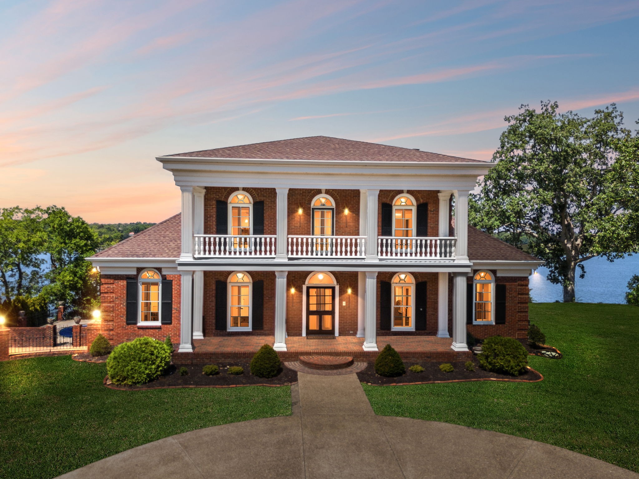 Welcome to Windsong, your private lakeside retreat on beautiful Old Hickory Lake~ This timeless Colonial Style homes sits on 1.25 acres offering the most breathtaking year-round views of the water and sunsets. This home was thoughtfully designed in every aspect! Step through the front door and be greeted to rich architectural details. Features include an expansive chef's kitchen, elevator that accesses all three levels, 3 fireplaces, 3 crystal chandeliers, a staircase like no other, beautiful cherry and mahogany wood details, 4 covered porches, in-ground pool, and a gated driveway lined with New Orlean style lamp posts. The main level is perfect for family gatherings and entertainment.  Upstairs, the primary suite includes a fireplace, sitting area, ample closet space and sweeping lake views. The versatility of the basement includes a living room, kitchen, and large workout space. Windsong is tucked away in a quiet setting, yet minutes to the city, airport and shopping.