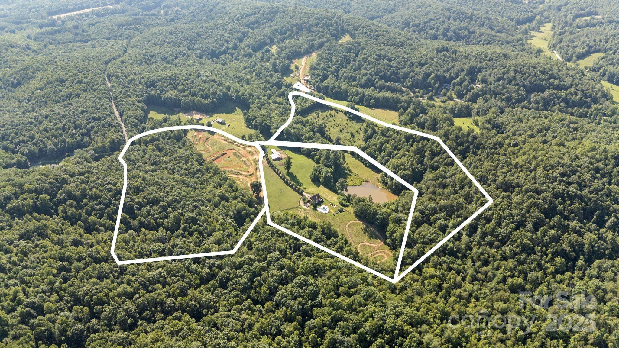 Live your dream on this 49-acre organic farm paradise with year-round mountain views in the breathtaking foothills of Caldwell County! Adventure, serenity, and self-sufficiency await with a stocked pond, vibrant raised-bed garden, fruit trees, and fenced pastures with a barn—perfect for animals or hobby farming. Blaze your own trail with horseback riding paths and three adrenaline-pumping motocross dirt tracks! Cool off in the in-ground heated & cooled saltwater pool, then soak under the stars in the hot tub. The charming 3BR/2.5BA two-story home with a basement offers cozy comfort and room to expand. Whether you're seeking a homestead, family retreat, or recreational haven, this rare property offers it all—nature, play, and peaceful living in one unforgettable setting. Don’t miss your chance to own a lifestyle, not just a home!