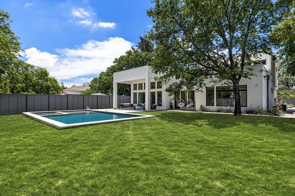 Immaculate and move-in ready, this one-owner 2016 custom home by Justin Jeffrey Homes offers 6,103 square feet of refined living in coveted Preston Club Estates. Behind a motorized entry gate and gated front courtyard, discover a sophisticated 5-bedroom, 7 bath contemporary masterpiece where design and functionality meet at every turn. A custom glass iron front door opens to expansive living spaces featuring two gas fireplaces, a separate office with glass French doors, and designer lighting and hardware throughout. The chef’s kitchen is fully equipped with a 48” Wolf range, Gaggenau stainless steel refrigerator, two Bosch dishwashers, quartz countertops, under-cabinet lighting, and a walk-in pantry—ideal for both entertaining and everyday living. A stylish butler’s pantry and a dramatic glass-enclosed, backlit wine wall with built-in wine fridge complete the heart of the home. The primary suite overlooks the resort-style backyard and includes a spa-inspired bath with soaking tub, large glass-surround shower, and an oversized custom closet with a bonus storage closet. Two full laundry rooms offer added convenience. Outside, a private backyard retreat awaits with a 2022 PebbleTec pool, tanning ledge, and spa, surrounded by lush landscaping. This contemporary residence is the perfect balance of clean lines, thoughtful design, and modern luxury.