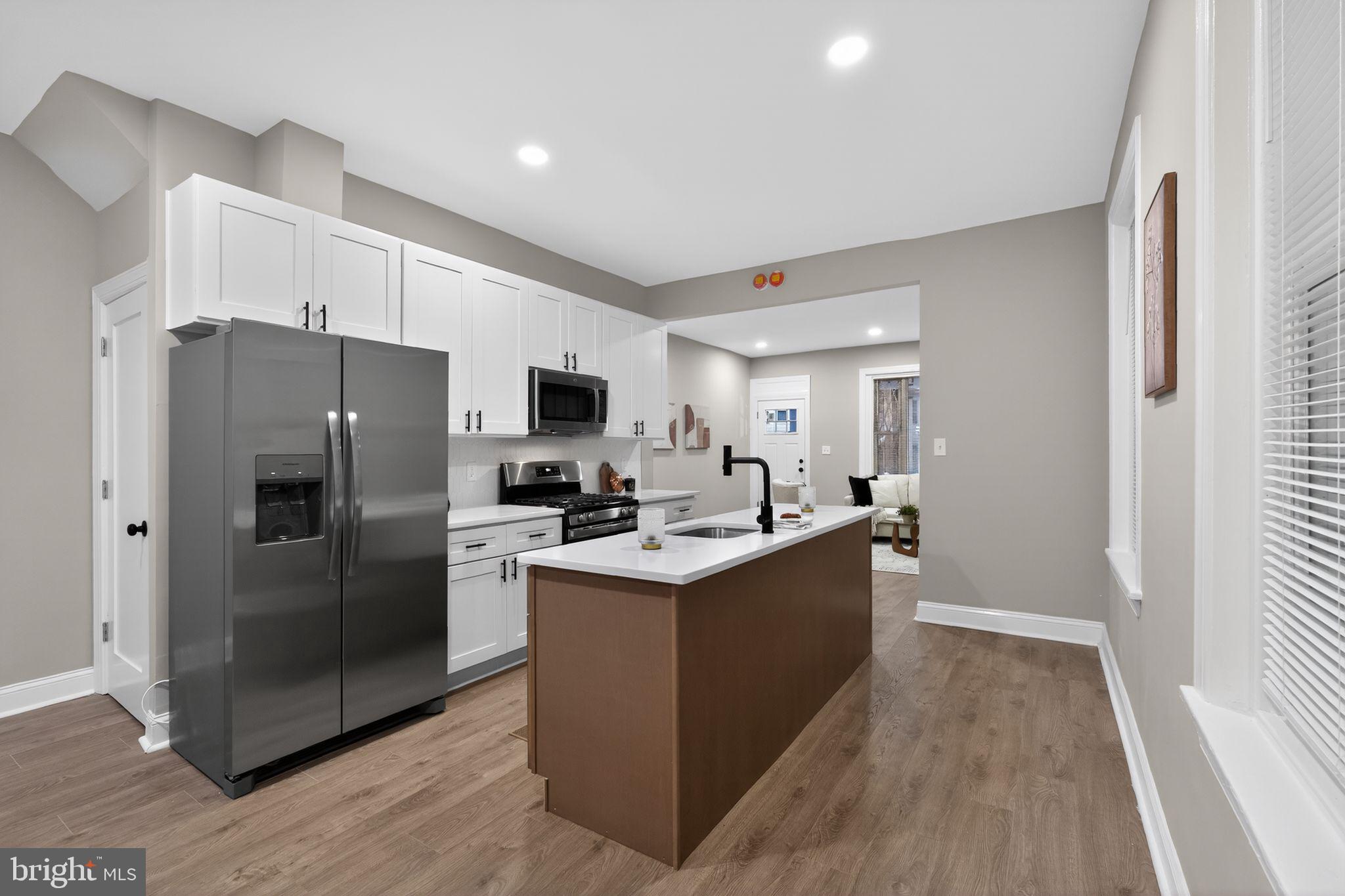 Welcome to this beautifully renovated 4-bedroom, 2.5-bathroom home located in the heart of Philadelphia. The main level has been completely redone and features brand-new laminate wood flooring throughout the living room, dining room, and kitchen, creating a seamless and modern flow. The stunning kitchen has been fully renovated with white shaker cabinets, granite countertops, chic black hardware, and stainless steel appliances. A stylish center island with wood-toned shaker cabinetry, white granite countertops, and a built-in dishwasher adds both functionality and visual appeal. A newly renovated half bathroom completes the main level.The second floor offers three spacious bedrooms, all finished with brand-new wall-to-wall plush carpeting, along with a newly renovated full bathroom. The third level is dedicated to the expansive primary suite, featuring brand-new plush carpeting and a truly impressive en-suite bathroom. This oversized bathroom includes new ceramic tile flooring, a soaking tub, a separate glass-enclosed shower, a high-end vanity, and a new commode, offering a spa-like retreat. Additional highlights include brand-new central air conditioning, making this home completely move-in ready.