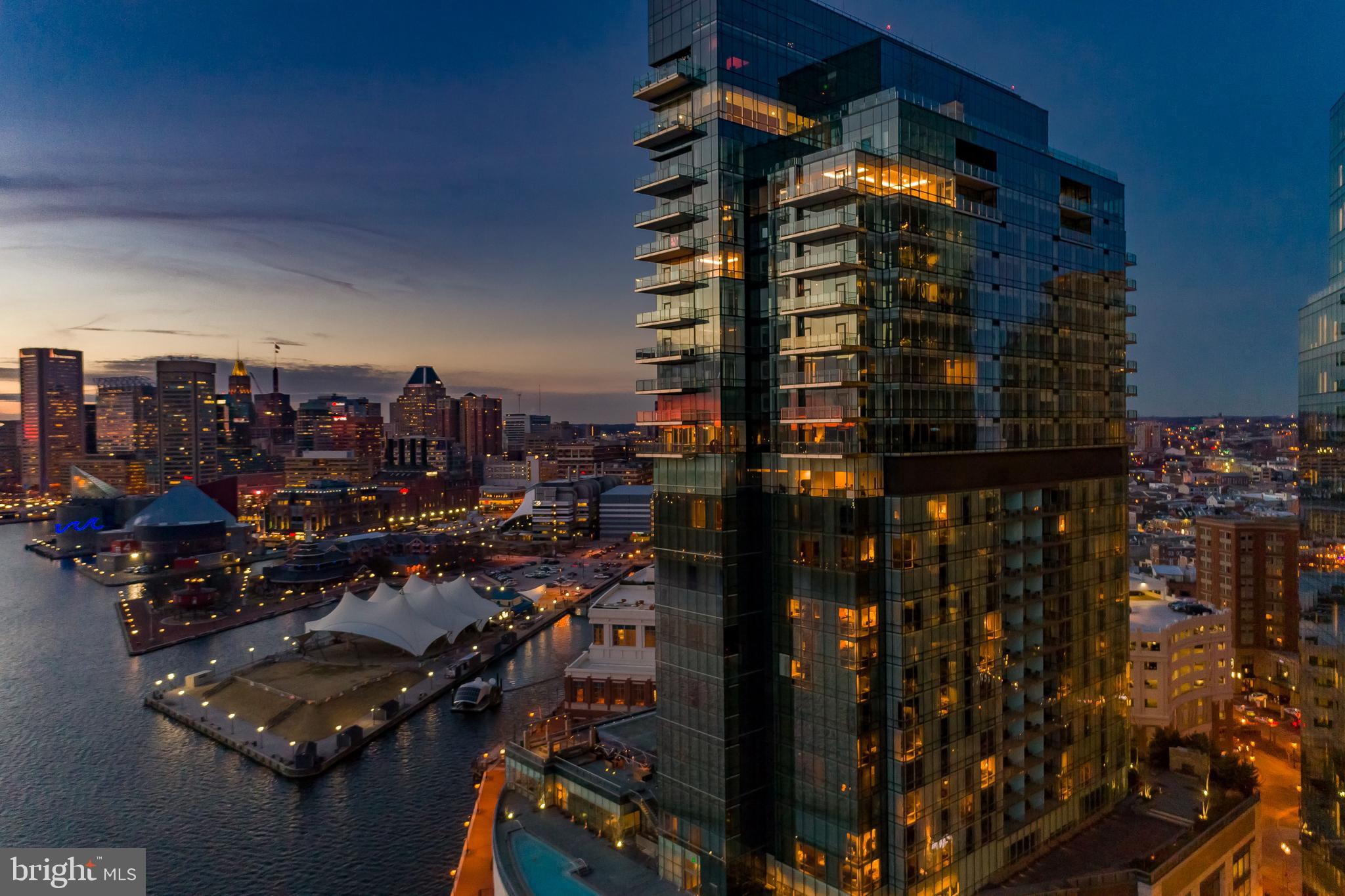 Experience elevated living from this 22nd-floor corner residence in the prestigious Four Seasons Private Residences in Baltimore's sought-after Harbor East. This extraordinary three-bedroom, three-and-a-half-bath home, complete with a media room, spans over 3,100 square feet, offering panoramic views of the Patapsco River, Domino Sugar, downtown skyline, and Baltimore’s iconic Inner Harbor. Designed for those with a discerning eye, the open-concept layout flows seamlessly between the living, dining, and kitchen areas, all under airy 10-foot ceilings and surrounded by floor-to-ceiling windows. A spacious balcony invites you to take in the breathtaking views. Luxury abounds with walnut herringbone wood flooring, vaulted ceilings, designer light fixtures, custom built-ins, motorized shades, and a state-of-the-art home automation system. The chefs kitchen is a masterpiece, featuring an oversized eat-in marble waterfall island, professional-grade Miele appliances, Eggersmann cabinetry, and custom Sub-Zero wine refrigeration. The serene primary suite offers a separate dressing room, a generous walk-in closet, and a marble-clad en-suite bath complete with a dual vanity, walk-in steam shower, and a freestanding soaking tub. As a resident, you’ll enjoy the signature Four Seasons service and amenities that redefine luxury living. From personalized lifestyle services to long-term property management, the Four Seasons Private Residences Baltimore promises a refined, worry-free ownership experience in Harbor East’s most coveted location.