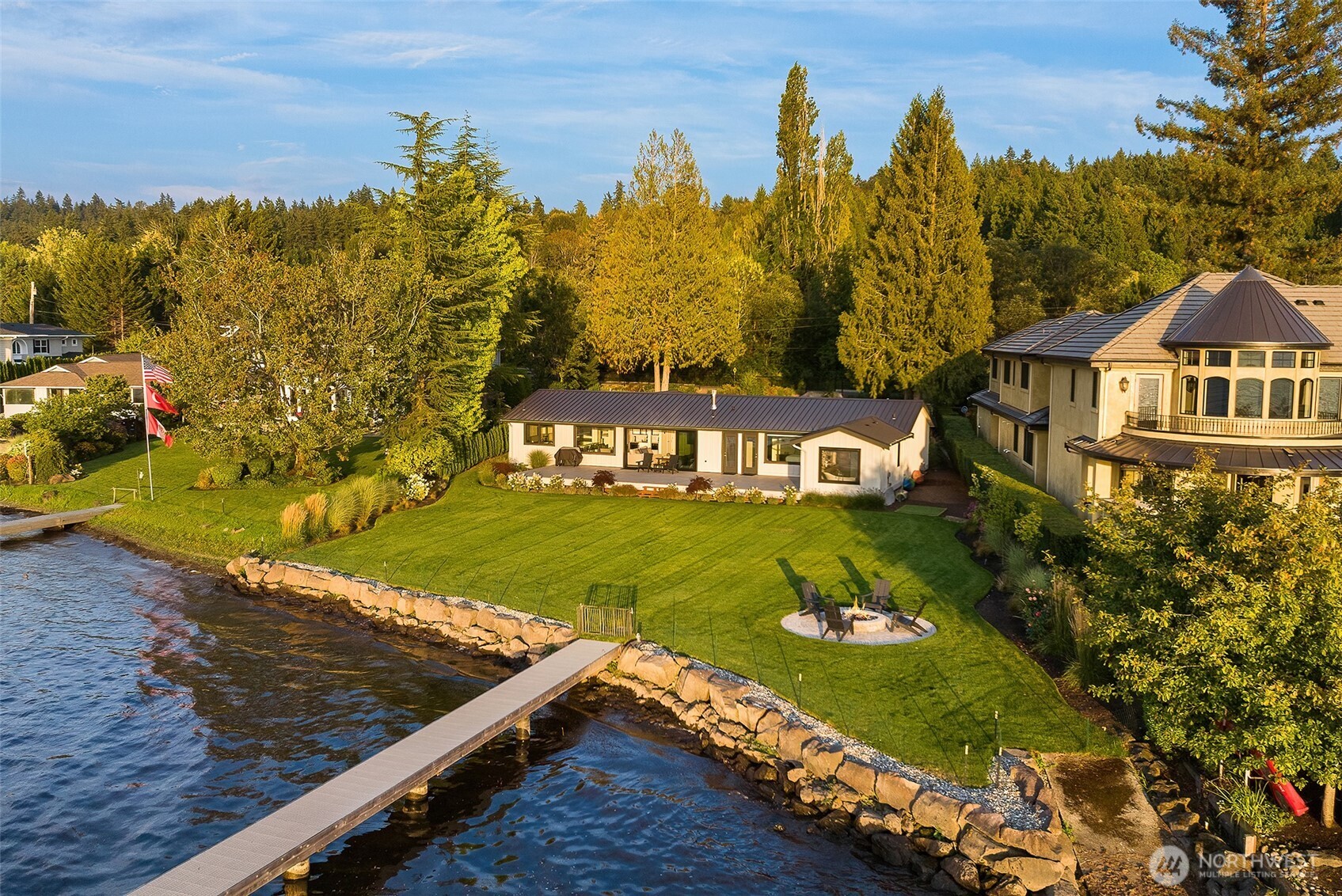 Welcome to this rare custom waterfront rambler, completely rebuilt in 2024. This immaculate home offers 3 bedrooms, 3 baths, and 2,290 sq ft of exceptional living space along 101 feet of pristine Lake Sammamish shoreline. This smart home features a stunning kitchen with high-end appliances, quartzite countertops, a built-in butler's pantry, and center island beneath soaring vaulted ceilings. The amazing primary suite is complemented with a bathroom that has heated floors, heated towel bar, walk-in closet and view of the lake. Other interior highlights include: floor to ceiling sliding glass door that opens all the way, heated floors in all other bathrooms, and electric blinds throughout. Blinds, lights & TV controlled by Crestron Smart Home System. Step outside to a professionally landscaped level yard with a spacious entertainment deck and gas firepit. Additional highlights include a whole-home generator, A/C, a new dock with three lifts, a long-lasting metal roof, and board & batten siding — all within a top-rated school district.