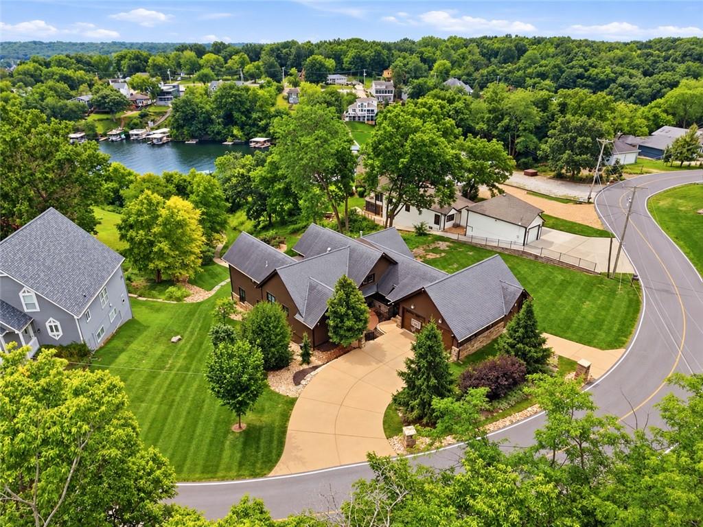 Discover elegance, privacy, and exceptional lakefront living in this meticulously maintained 5-bedroom, 4-full-bath, 2-half-bath residence situated on an impressive 2.5 lots, offering a full lot of separation from each neighboring property! This stunning home boasts extensive upgrades completed within the last three years, including a complete luxury kitchen remodel, all-new hardwood flooring throughout the upper level, and numerous additional enhancements. Soaring ceilings on both levels, exquisite custom cabinetry, premium Sub-Zero, Fulgor, and Asko appliances, and two gas fireplaces create an atmosphere of timeless luxury. Two primary bedrooms with breathtaking lake views feature private ensuite baths, while a third bedroom also offers its own private ensuite, providing exceptional comfort and privacy for family or guests. Upgraded lighting, surround sound, custom plantation shutters, and Marvin windows and doors elevate the home's sophisticated appeal. Step outside to your private waterfront oasis featuring a swim dock, boat dock with lift, expansive low-maintenance deck, and beautifully landscaped grounds complete with a pond, creek, and lower patio. Thoughtful landscaping ensures exceptional privacy and tranquility. Additional highlights include a custom three-car garage, three-zone HVAC, and a beautifully designed den doubling as a secure storm shelter. Experience refined lakefront luxury and the extraordinary Lake Lotawana lifestyle!