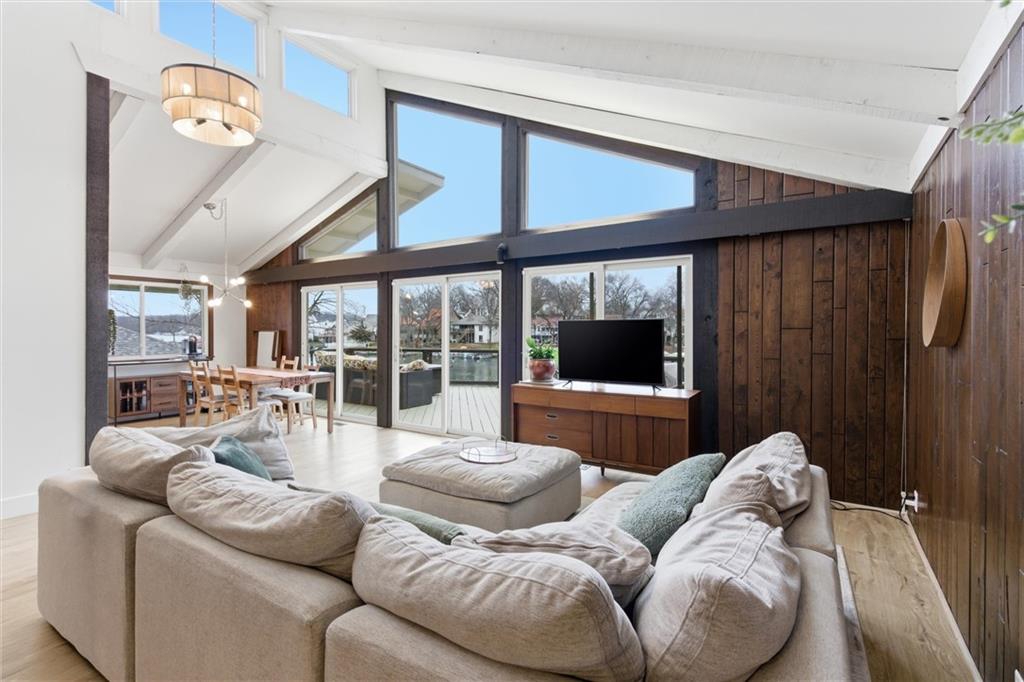 Mid-century modern AND lake front!Tucked back in a quiet cove yet perfectly positioned for long, open views down the main channel, this updated mid-century modern lakefront home delivers the best of Lake Tapawingo living. The setting is peaceful, the views are expansive, and the water access is exceptional — complete with your own dock and an impressive seawall featuring wide concrete steps that make swimming and lake days effortless.Inside, you’ll find over 3,000 square feet, five bedrooms, and four baths, thoughtfully updated while preserving the character that makes mid-century design so timeless. Clean lines, warm details, and architectural touches remain, blended seamlessly with modern finishes.The main level is designed for everyday comfort and easy entertaining. The primary suite is conveniently located on this floor with a private en suite bath and generous closet space. Additional rooms and a main bath flow naturally toward the heart of the home — a stunning living room anchored by a grand fireplace, open to the kitchen and framed by floor-to-ceiling windows that showcase both the architecture and the lake beyond.Downstairs, the vibe shifts into full lake-life mode. A second living area features a completely renovated bar, creating the perfect space for hosting friends after a day on the water or gathering for weekend lake parties. Additional rooms down the hall offer flexibility — home offices, guest rooms, workout space, or whatever fits your lifestyle.Beyond the home itself, Lake Tapawingo is known for its strong sense of community. Neighbors know each other, events fill the calendar, and the lake becomes a shared backdrop for daily life. Boating, kayaking, wakeboarding, fishing, swimming — it’s all right outside your door.Architectural, inviting, and set in one of the most special lake communities around, this is a home that truly needs to be experienced in person to be appreciated.