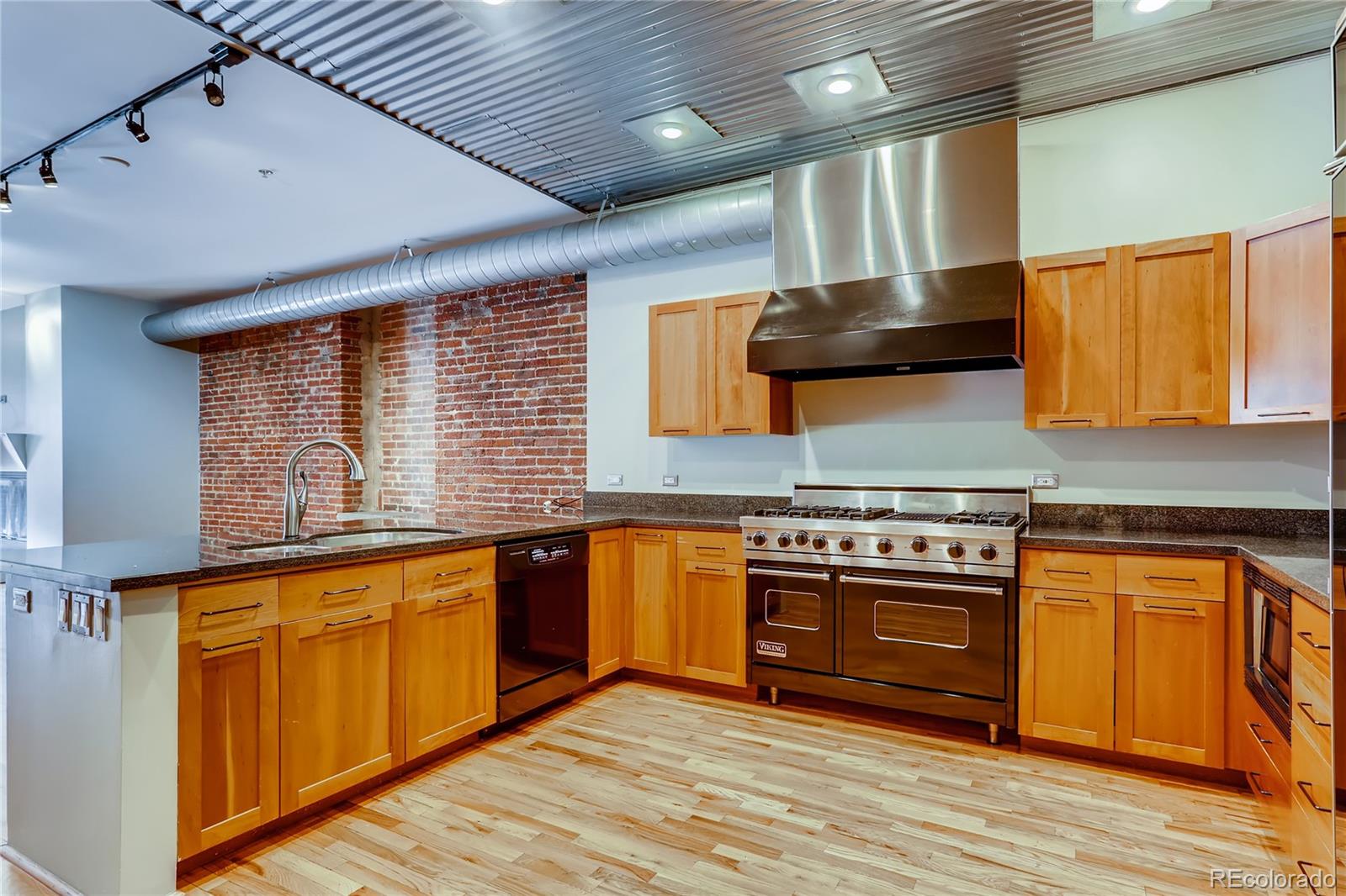 Best Price Per Foot Downtown!!  Why pay the same price for half the square feet?  This spacious 3000+ sq ft loft, with exposed brick throughout, right in the heart of downtown, is an absolute stunner.  The location can not be beat - easy access to freeways, but just steps from the Cherry Creek Trail, and all sporting venues.  The open floorplan flows very well.  A large kitchen with Viking Range and granite counters opens into the dining room.  The living room is then directly adjacent, with its huge gas fireplace and large windows, providing plenty of natural light.  The beautiful brick has many recesses and art niches.  The primary bedroom is HUGE - 39 feet wide - plus its own balcony, a luxurious 5 piece en suite bath and a large walk-in closet.  The secondary bedrooms are also quite spacious, with ample closets, plenty of storage.  In the basement, there is a temperature controlled wine locker and a large deeded parking space, #2.
