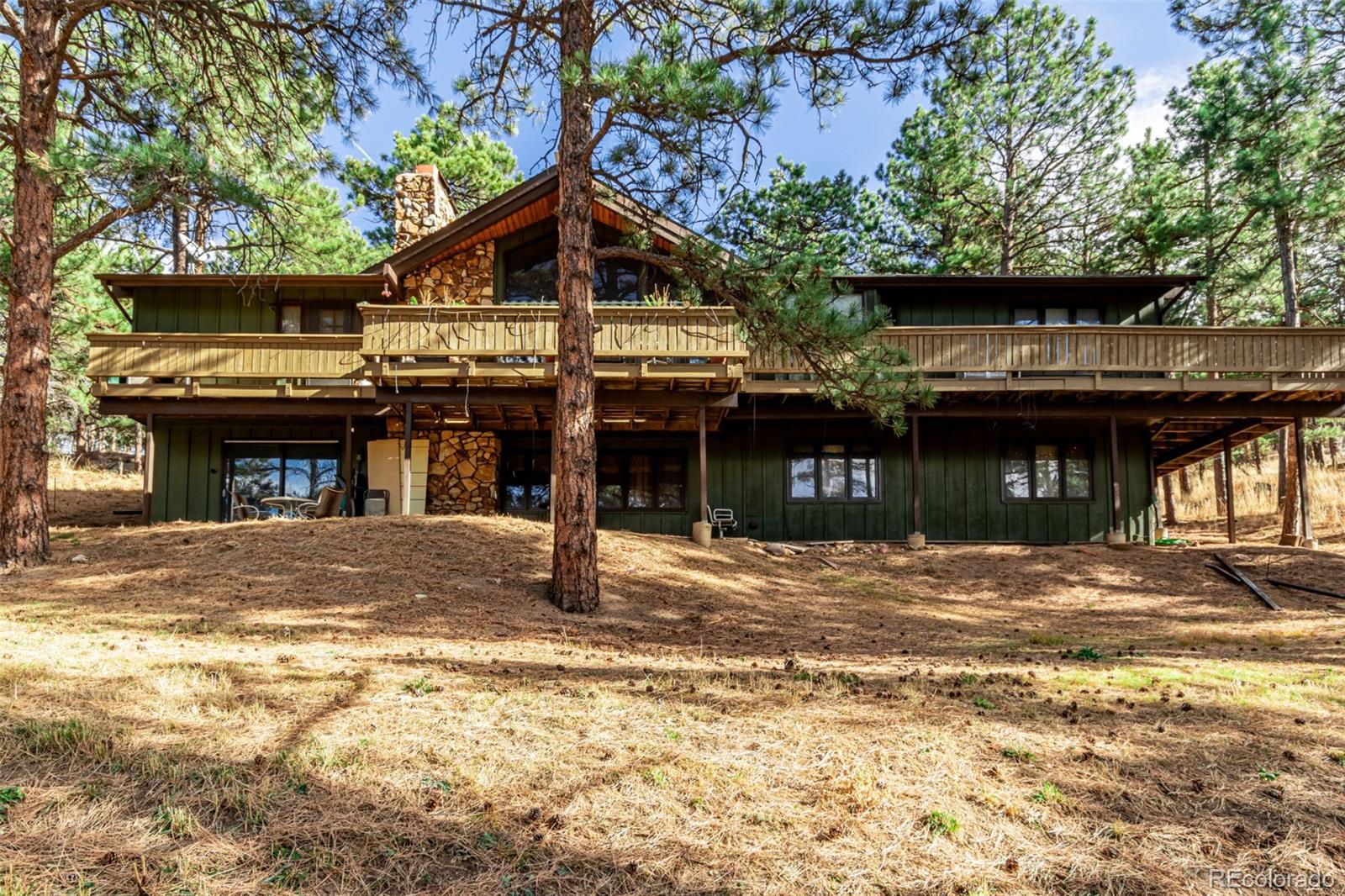 Welcome to 228 Alder Ln — a rare opportunity to build your dream mountain estate or renovate the existing residence atop the prestigious Pine Brook Hills community in Boulder. Set on a picturesque and secluded 1.5-acre lot with commanding western views of the Continental Divide, this property offers true Colorado mountain living just 15 minutes from Downtown Boulder. The existing residence spans nearly 4,000 sq ft. The main level features three bedrooms plus a spacious primary suite, along with an open, light-filled living room that frames sweeping Divide views and opens to a wraparound patio. The walkout lower level adds three additional bedrooms and flexible space for guests, offices, or recreation. A detached two-car garage, mature trees, and excellent separation from neighbors elevate the sense of privacy.Whether you're envisioning a custom build or looking to reimagine the current home, 228 Alder Ln offers unmatched views, tranquility, and proximity to Downtown Boulder.