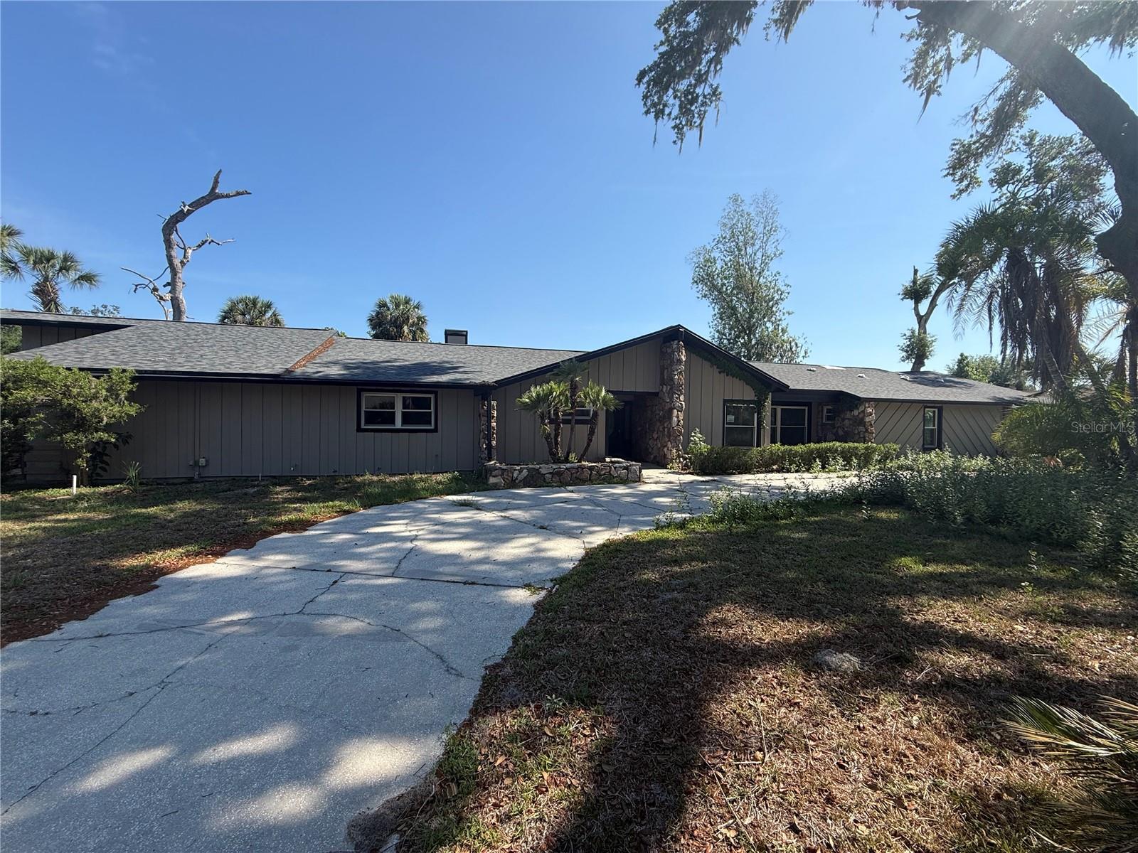 Rare opportunity in established River Rapids! One street neighborhood with NO CDD/LOW HOA and on 1/2 acre.  Unique home originally built in 1978 has gone through many changes over the years.  This home offers 5 bedrooms, 3 bathrooms, 3 car garage, 3776 square feet and a screened pool. The floorplan has plenty of flexibility and charm.  Traditional formal living and dining room greet at the front of the home and then a few steps in it opens up to- wow!  HUGE family room with fireplace and views of the pool through multiple glass French doors.  The kitchen is set off of the family and beyond is 1 bedroom, a laundry room and the side 3 car garage entry.  Bonus room off of the family room is perfect for a home office or play area, complete with washup sink area or wet bar.  Down the hall find 3 secondary bedrooms, one with an en suite bath. One of the secondary bedrooms has 3 huge windows open to the side entrance at the end of the hall (see pictures)- perfect for a studio or showroom.  The primary suite has a fireplace, private open patio and walk in closets.  Primary bathroom has 2 sinks and walk in closets. Storm damage is evident although this seller does not have a history on the home. Code violations exist and this will need to be taken on by the buyer and sold 'as-is/where-is'.