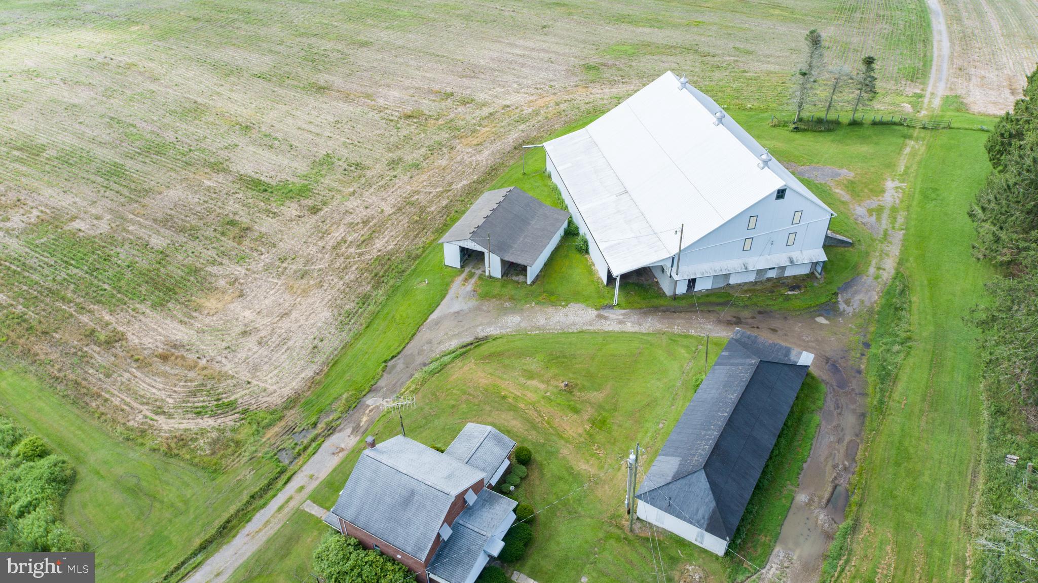 Versatile 166-Acre Property with Prime Access to I-68 and U.S. Route 219Located at the strategic junction of I-68 and U.S. Route 219, this approximately 166-acre property offers a rare combination of size, accessibility, and development potential. Currently operating as a working farm, the land includes roughly 110 acres of tillable fields, 44 wooded acres, and an established pond with a small cabin—ideal for recreational use or future enhancement.The property sits directly along the eastbound on-ramp to I-68, offering exceptional visibility and access. With public water nearby and the high-traffic corridor to Deep Creek Lake and Wisp Resort just minutes away, this site is ideally positioned for a wide range of commercial uses. Potential options include a truck stop, retail or service center, hospitality venues, or a mixed-use development. Approximately 8 acres are currently leased to a concrete barrier company, providing income and potential for industrial use in a designated section of the property.The property features seven distinct structures that add versatility and value, including a comfortable main residence, a historic 1800s farmhouse ideal for restoration or hardwood reclamation, and a large traditional barn with a full loft and stalls suited for livestock, storage, or events. Supporting agricultural and mechanical operations are a fully equipped machine shop, a spacious farm equipment garage, and a modern 40' x 100' metal building with a hydraulic crane lift, concrete floor, and high ceilings for industrial use. Rounding out the amenities is a charming cabin by the pond, perfect for recreation, weekend retreats, or rental potential.Whether maintained as a productive agricultural operation, developed into a commercial hub, or configured for a blend of both, this property offers a strong foundation in a high-growth corridor. Recreational appeal, proximity to key destinations, and diverse infrastructure make this an uncommon investment opportunity.