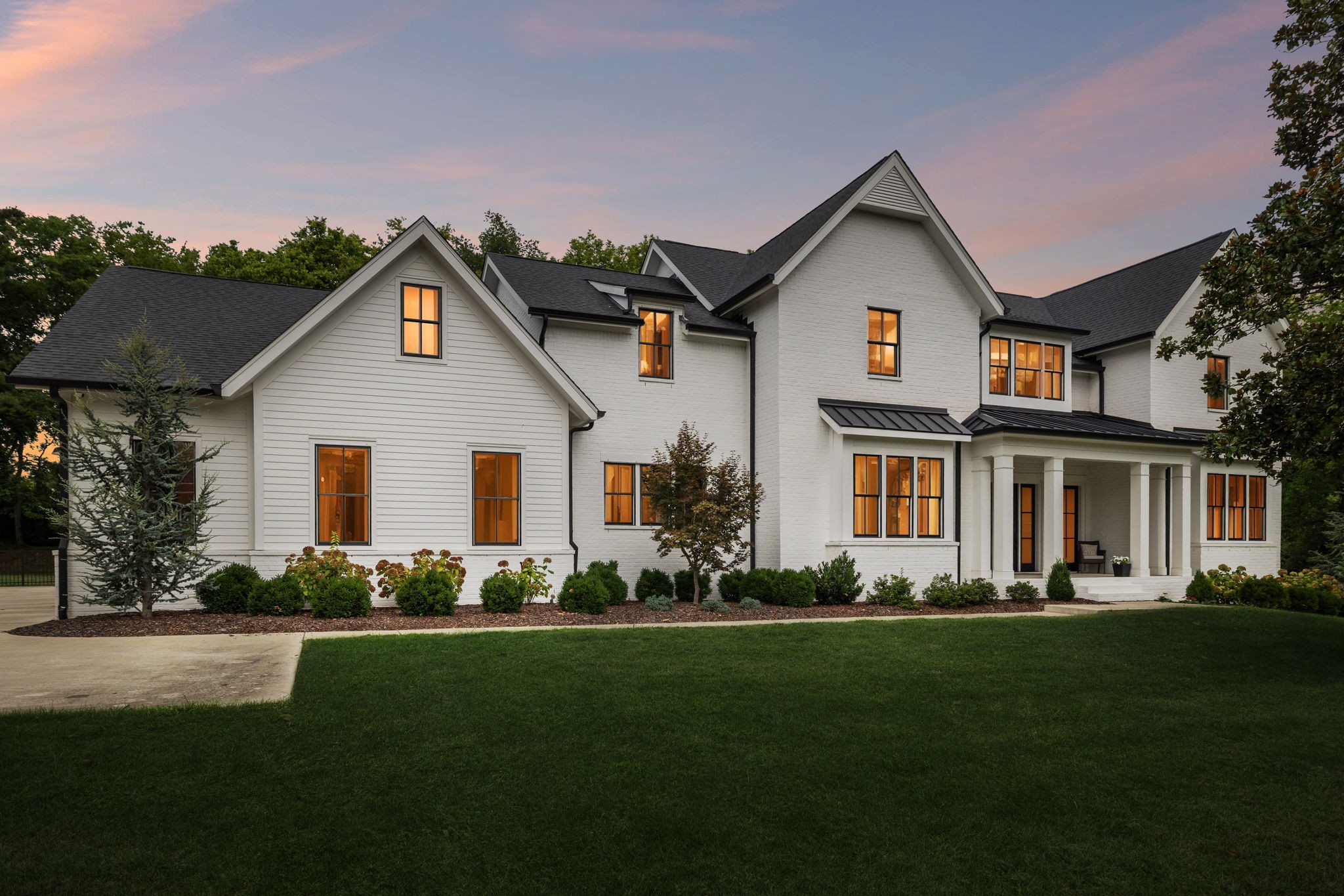 Luxury, comfort, and convenience meet at 5116 Williamsburg Rd in the sought-after Meadowlake community of Brentwood. From the moment you arrive, the beautiful white brick exterior, welcoming covered front porch, and inviting entry foyer set the tone for the elegance inside. Just off the foyer, the formal dining room features a shiplap accent wall, creating a seamless connection to the home’s timeless design details. The heart of the home is the gourmet kitchen, boasting top-of-the-line appliances, ceiling-height cabinetry, a large center island, quartz countertops, a hidden walk-in pantry, and a spacious breakfast nook with a continued shiplap accent wall. The adjoining living room offers a cozy fireplace framed by wooden beams, custom built-in shelving, and dual French doors that open to the covered back porch—perfect for indoor-outdoor living. The main-level primary suite is a private retreat, showcasing a vaulted shiplap ceiling, bay window seating area, and a spa-inspired bath with a stand-alone soaking tub, double vanities, a dedicated makeup station, built-in tile bench in the shower, and a walk-in closet with custom storage. A guest suite on the main floor provides ideal accommodations for visitors. Additional thoughtful touches include a drop-zone with hooks and a bench, and a large laundry/utility room with generous counter space, hanging rods, and even a desk work area. Upstairs, you’ll find a dedicated office or creative space, a spacious bonus room with a wet bar and beverage center, three more bedrooms, two full baths, and abundant unfinished storage space—offering room for future expansion. Step outside to your private 1-acre, fenced backyard oasis, complete with a covered porch featuring a fireplace, a sparkling heated saltwater pool, and an integrated spa—all backed by mature trees for privacy. Zoned for Williamson County’s award-winning schools and ideally located near shopping, dining, and I-65, this home offers the ultimate living experience.