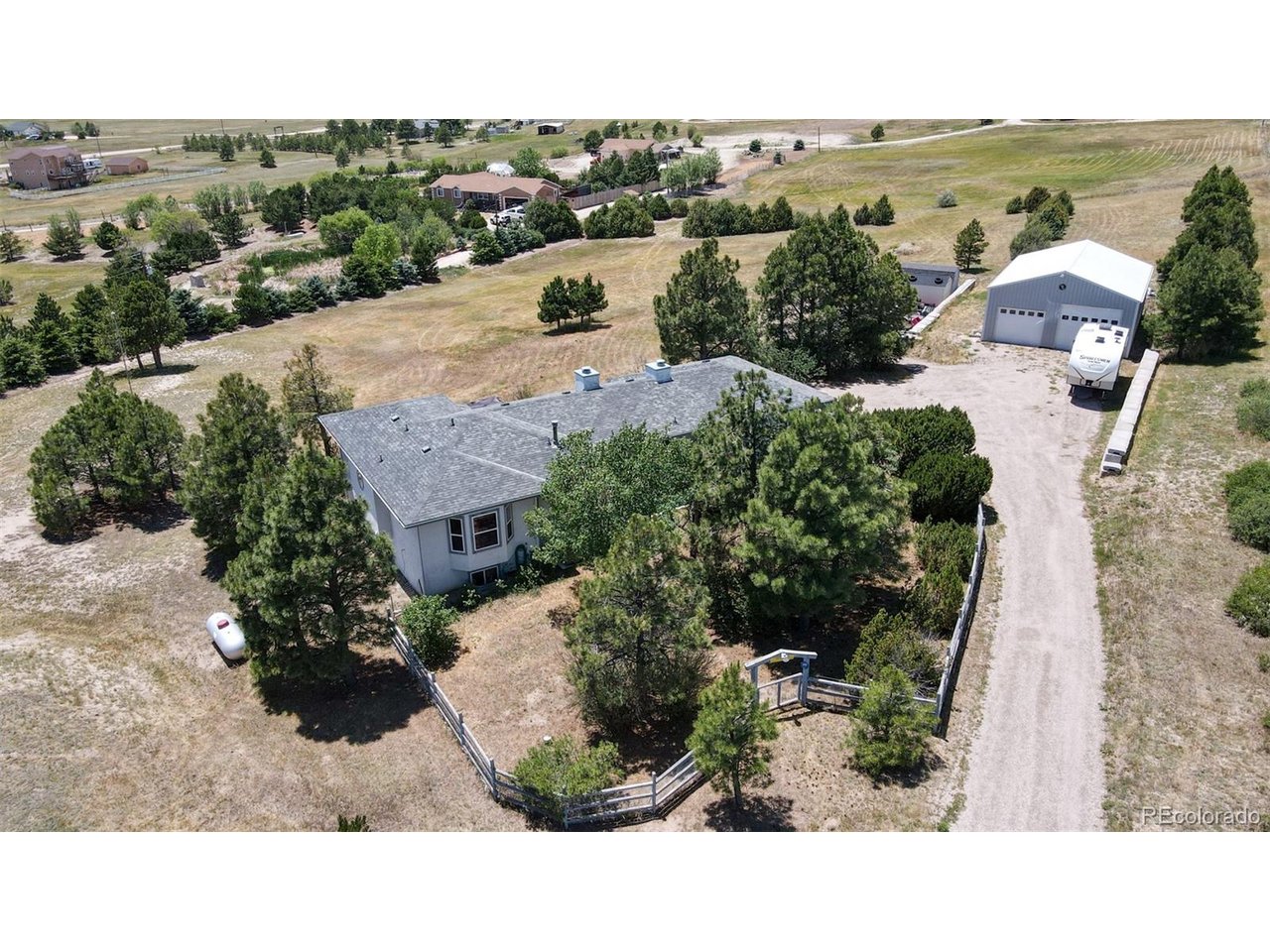 Discover the perfect blend of country living and modern convenience with this peaceful walk-out rancher. No HOA, no citynoise, just wide-open space with everything you need not far away. Set on a partially treed lot with mountain views and atrue homestead feel, this property delivers privacy, space, and opportunity in equal measure. For the car enthusiast orserious hobbyist, the fully built-out heated detached garage and workshop is the crown jewel of this property. Set up andready to go from day one, this is the dream shop and man cave you've been looking for with no buildout required. Stepinside to the open living room featuring vaulted ceilings and a three-sided gas fireplace. The space flows effortlessly to theback deck where you can unwind and soak in the mountain backdrop. The eat-in kitchen offers an island, ample cabinetspace, and direct access to the attached two-car garage. The home provides four bedrooms with thoughtful storagethroughout, including three walk-in closets, with two bedrooms conveniently located on the main level. Head downstairs tothe walk-out basement where you'll find a spacious family room with wood burning fireplace, two additional bedroomscurrently being used as offices, a full bathroom, and a laundry room complete with washer, dryer, and utility sink. The lowerlevel opens directly to a private patio with a hot tub, creating your own personal retreat at the end of the day. Zoned forDistrict 49 schools and ideally suited for homeschooling, remote work, or multi-generational living, this country estate sitson that rare sweet spot. Far enough from the city for peace and quiet, yet close enough to shopping, groceries, and everydayamenities that you never feel far from anything. With its serene setting, functional layout, and room to customize, thisproperty is ready for its next owner.
