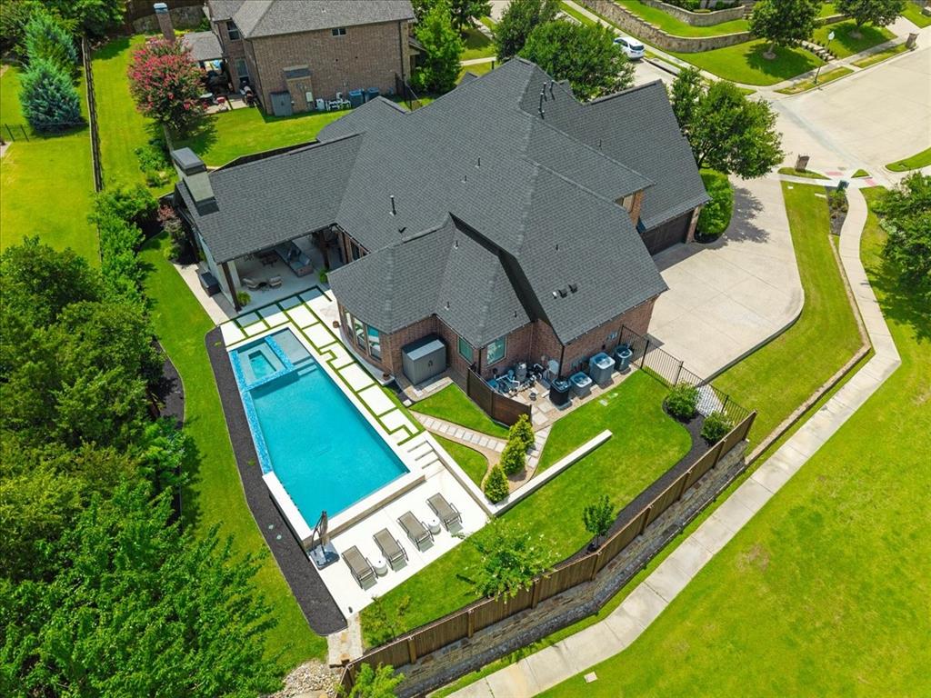 Welcome to 1521 Spanish Bay Drive, a stunning custom home in Keller’s prestigious Spyglass Hill Estates. Perfectly positioned beside lush green space and just steps from a beautiful city park, extensive trail system, and City Hall, this residence delivers an unbeatable blend of privacy, convenience, and elevated Texas living. Step through the impressive wrought iron front door into warmth and timeless elegance. Thoughtful updates throughout include a durable Class IV roof replacement, fresh interior and exterior paint, and a show-stopping kitchen with elegant Taj Mahal quartzite countertops paired with premium Monogram appliances. Quartz counters in all secondary bathrooms complete the refined interiors.A sophisticated indoor-outdoor audio video system ties the home together seamlessly, delivering immersive sound and entertainment from the spacious living areas to the backyard. Whether hosting inside or relaxing outside, the system creates the perfect atmosphere for every occasion.Outside, the spectacular 2022 custom pool and backyard living oasis is the true highlight. Featuring a sparkling pool, relaxing hot tub, full outdoor kitchen, and integrated audio, video, this private retreat is designed for unforgettable entertaining and everyday enjoyment under the Texas sky. It’s your personal resort that buyers will love. Meticulously maintained and thoughtfully updated, every detail creates a true sanctuary. Don’t miss the opportunity to make 1521 Spanish Bay Drive your own, where luxury living, effortless comfort, and sophisticated indoor-outdoor entertainment come together in one of Keller’s most desirable neighborhoods.
