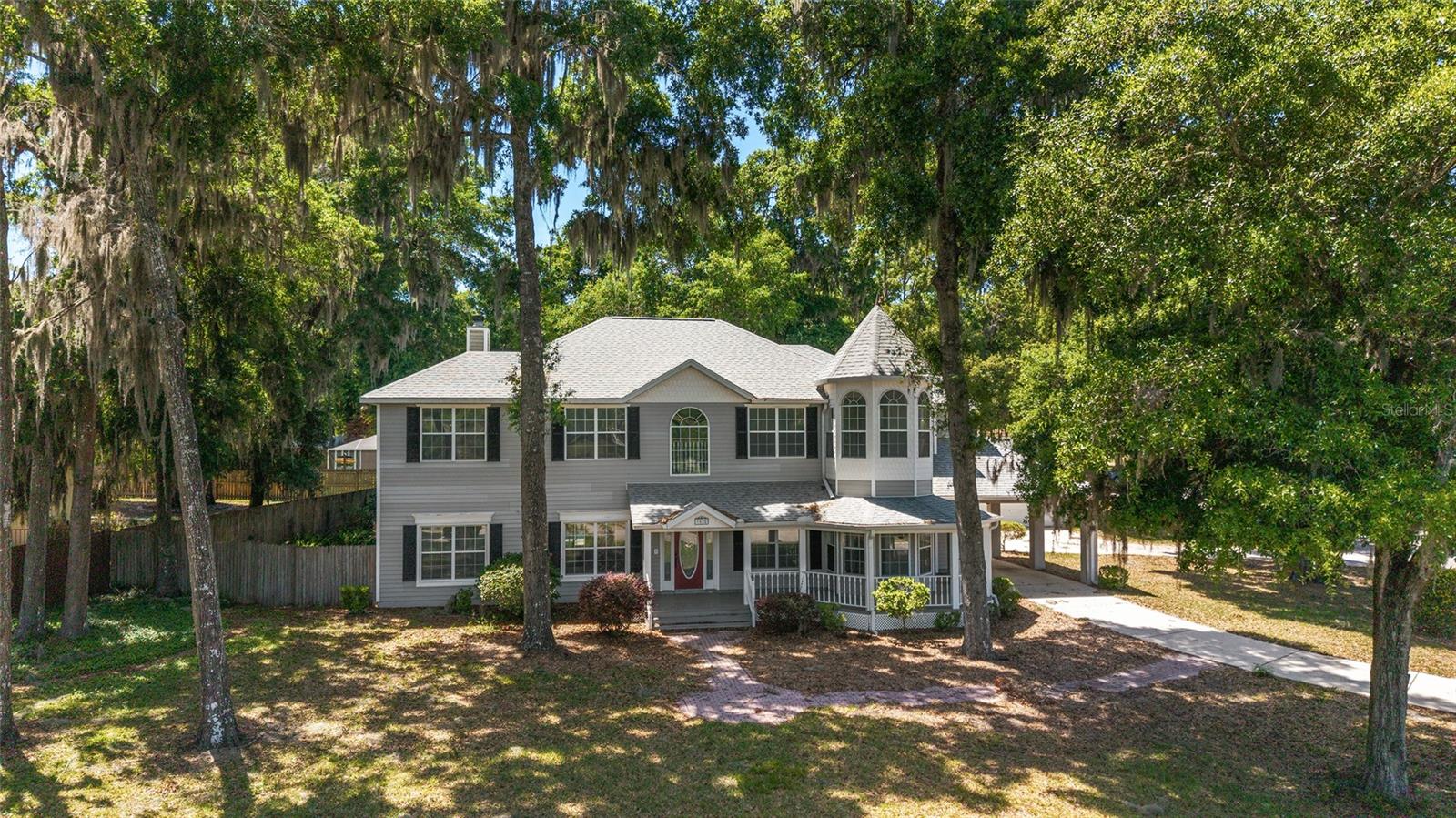 Welcome to this stunning Victorian-inspired residence, where timeless architectural charm meets modern comfort and thoughtful design. Offering five bedrooms and four full bathrooms, this beautifully renovated home provides exceptional space, flexibility, and functionality—ideal for multigenerational living or those relocating and seeking a move-in-ready lifestyle.Perfectly positioned in a desirable area near the Frank DeLuca YMCA, Publix, parks, shopping, dining, and top-rated schools, the location offers both everyday convenience and a strong sense of community.From the moment you arrive, the inviting wraparound porch sets the tone, overlooking a peaceful private pond and creating the perfect space to unwind. Inside, the home showcases a seamless blend of character and modern upgrades, including high ceilings, a formal living room, and a dedicated dining space designed for both entertaining and daily living.The fully updated kitchen serves as the heart of the home, featuring stone countertops, new cabinetry, updated appliances, and ample space for casual dining. Designed with versatility in mind, the property offers primary suites on both the main level and upstairs, along with laundry rooms on each floor—providing comfort and convenience for extended family, guests, or flexible living arrangements. Dual staircases further enhance accessibility and flow throughout the home.Step outside to your private outdoor retreat, complete with a screened-in pool and generous patio space, ideal for year-round enjoyment. The detached three-car garage and additional parking provide ample room for vehicles, storage, or hobby space, while the covered portico offers added convenience during Florida’s seasonal rains.Recent improvements—including a new roof, HVAC system, pool pump, and garage door opener motors—offer peace of mind for buyers seeking a turnkey property. Combining Victorian-inspired design with modern updates, scenic surroundings, and a highly convenient location, this home presents a rare opportunity for those seeking space, comfort, and long-term livability.A must-see property for buyers looking to relocate or accommodate multigenerational living without compromising style or function.