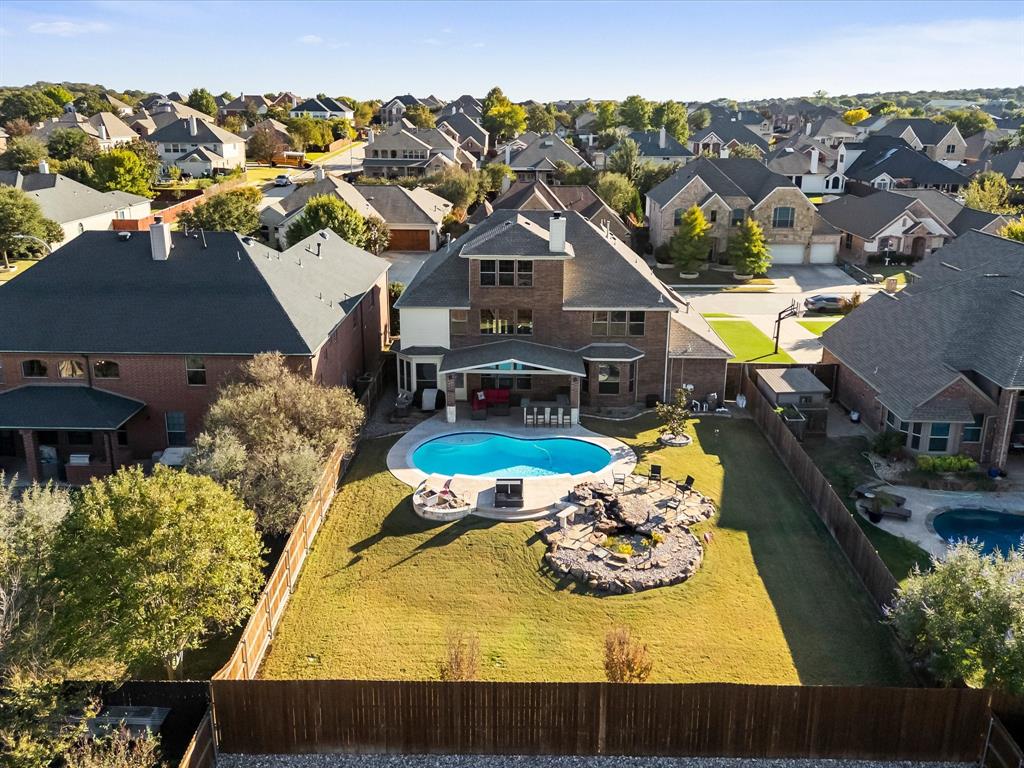 Discover luxury living in this stunning, rare, three-story brick and stone home located in the highly sought-after Keller ISD, known for top-rated schools and exceptional community appeal. This move-in ready home with a rare three-car garage offers the perfect blend of elegance, space, and modern functionality—ideal for multi-generational living, remote work, and upscale entertaining. Step inside to a light-filled open-concept floor plan featuring soaring ceilings and designer touches throughout, anchored by a chef’s gourmet kitchen with a large island, granite countertops, stainless steel appliances, walk-in pantry, custom cabinetry, and bright bay windows, all seamlessly flowing into the spacious family room. Upstairs, a versatile game room with a charming Juliet balcony adds architectural character and flexible living space, while the third-floor bonus room with wet bar is perfect for a media room, guest suite, home office, or private retreat. The luxurious primary suite offers a spa-like bathroom with dual vanities, soaking tub, separate shower, and an expansive dual-entry walk-in closet for optimal organization. Step outside into your private backyard oasis featuring a sparkling pool, covered patio, built-in outdoor kitchen, lush professional landscaping, sprinkler system, and a serene koi pond—perfect for year-round enjoyment. Ideally located near parks, walking trails, shopping, dining, and major highways, this exceptional home offers the ultimate combination of location, lifestyle, and luxury—schedule your private tour today!