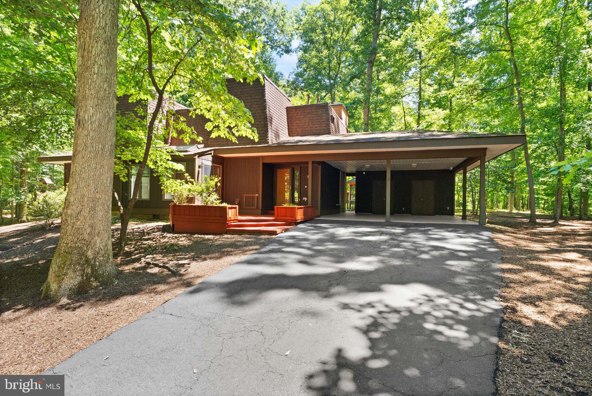 Welcome to this stunning contemporary home tucked away on a quiet cul-de-sac in the heart of Reston. Offering 4 bedrooms, 3 full baths, and 1 half bath across more than 2,800 finished square feet, this thoughtfully designed residence blends modern style, abundant natural light, and exceptional indoor-outdoor living.Step inside to discover a dramatic two-story living room highlighted by soaring floor-to-ceiling windows, a striking gas fireplace, rich hardwood flooring, and custom built-in cabinetry. Fresh paint throughout the home creates a bright, move-in-ready feel. The open-concept layout flows seamlessly into the beautifully appointed kitchen featuring shaker-style cabinetry, granite countertops, stainless steel appliances, and ample workspace for everyday living and entertaining. The adjacent dining area is filled with natural light from skylights and expansive windows, creating an inviting space for gatherings.The main level includes a spacious primary suite with private deck access, custom closet storage, and a spa-inspired ensuite bath featuring heated floors, dual vanities, a frameless glass shower, and direct access to the backyard retreat. Brand-new carpet adds comfort and style to the main-level bedrooms. A second generously sized bedroom, an additional full bath, powder room, and convenient laundry room complete the main level.Upstairs, you'll find another bright bedroom, a versatile office or study space with custom built-ins, and an additional full bath, offering flexibility for guests, remote work, or hobbies.Outdoor living shines with a private backyard oasis surrounded by mature trees. Enjoy relaxing or entertaining on the brick patio, gathering in the screened gazebo, or taking advantage of the expansive yard space. An extra-wide driveway and covered two-car carport provide ample parking and storage.Ideally located near Reston Association amenities, residents enjoy access to pools, tennis courts, and more than 50 miles of scenic walking and biking trails just beyond the backyard. Convenient to shopping, dining, commuter routes, and all that Reston has to offer, this exceptional home combines privacy, comfort, and an unbeatable location. Don't miss this rare opportunity to make it yours.