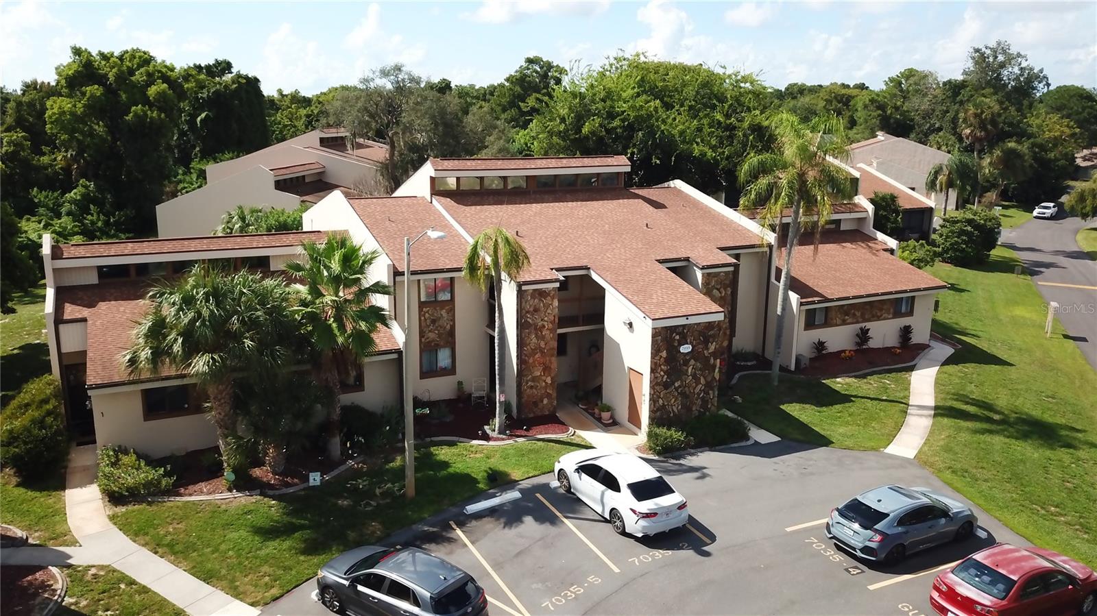Condo near downtown New Port Richey in park like setting perfect for walks enjoying nature with a pool, tennis court and shuffleboard court. This place is 2 bedrooms 2 baths with designated parking a front porch and a rear screened in porch on the second floor.  The master bedroom has its own mini-split for keeping it extra cold when you sleep along with a full 2.5 ton a/c that is brand new!  The master bathroom has been completely gutted and redone with a stand in beachy tile shower, new vanity, lights, facet and more.  The kitchen and many other rooms all have new Luxury Vinyl Plank Flooring that is light tan or cream toned. Appliances are newer and cabinets have been painted a light grey.  Bood your tour today so you can see it all for yourself and talk about how you may qualify for purchasing!  Washer and Dry room with washer included as well as shelving and there is also a storage closet outside of the unit and plenty of guest parking spaces for guests.