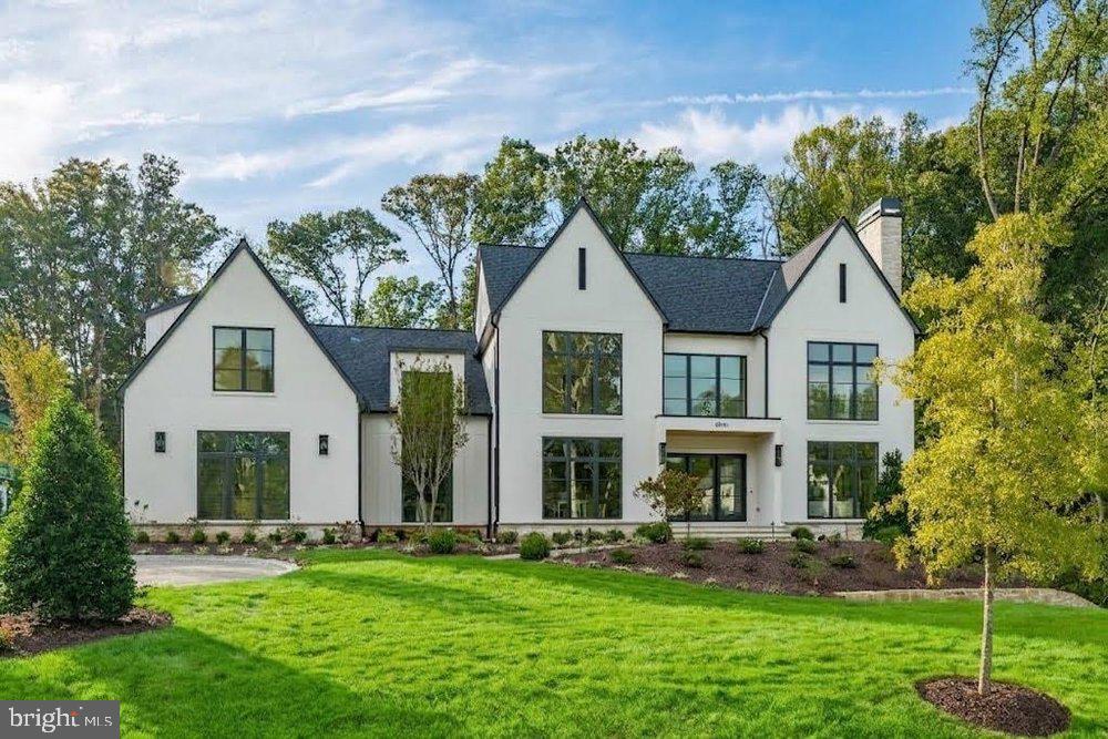 Quiet luxury has found a new address in Great Falls.At 800 Falls Farm Court, Brush Arbor Homes presents something truly rare: a New English Modern residence of exceptional confidence and presence, thoughtfully sited on 1.98 private acres. Here, architecture and landscape exist in quiet harmony, with every element composed to feel as though it belongs exactly where it stands.The façade makes an immediate impression with a refined palette of handsome stone masonry, finished with crisp white mortar and complemented by smooth stucco and nickel-gap siding. Traditional black shingles pair with a charcoal grey standing-seam metal roof, lending depth and distinction to the roofscape, while oversized custom Iron Ore Pella Lifestyle Series windows frame the home and draw natural light deep into the interiors. Tiered stone retaining walls, a substantial stone-clad façade chimney, manicured plantings, and a sweeping paver-lined drive create an arrival that is both understated and impeccably considered.Across approximately 11,600 square feet, three beautifully proportioned levels unfold with an effortless sense of scale. Six bedrooms, eight full and one half baths, dual staircases, 4 garage spaces and provision for an optional elevator accommodate grand entertaining and everyday living with equal ease. Formal gathering spaces transition naturally to more intimate family quarters and serene bedroom retreats, while wide-plank European white oak floors, soaring ceilings, and expansive walls of glass establish a warm, light-filled foundation throughout.At the rear, the home opens to a private outdoor retreat. An expansive cathedral-style covered porch, appointed with warm Radiata Pine ceilings and anchored by a substantial stone fireplace, creates a natural extension of the interior living spaces. From here, a flagstone patio carries the home seamlessly into the landscape. Above, a second-level balcony with black metal railings overlooks the grounds, offering a quiet vantage point from which to take in the setting. Beyond, the broad, level lawn provides an exceptional backdrop for recreation, entertaining, and everyday enjoyment, with the property designed to accommodate a future pool should the new owner desire one.Yet the true distinction of 800 Falls Farm Court is revealed in the details. Bespoke millwork and wainscoting, designer fixtures, furniture-grade cabinetry, and custom built-ins reflect a level of craftsmanship that rewards closer inspection. Each room possesses its own character while maintaining a seamless visual and architectural dialogue with the spaces around it—a reflection of design that is as intelligent and intentional as it is beautiful.800 Falls Farm Court represents Brush Arbor Homes at its finest: sophisticated without being showy, substantial without sacrificing warmth, and meticulously crafted from the ground up. For the discerning buyer, it is a home best understood in person.Schedule a private tour and experience a level of luxury that is not simply seen, but deeply felt.
