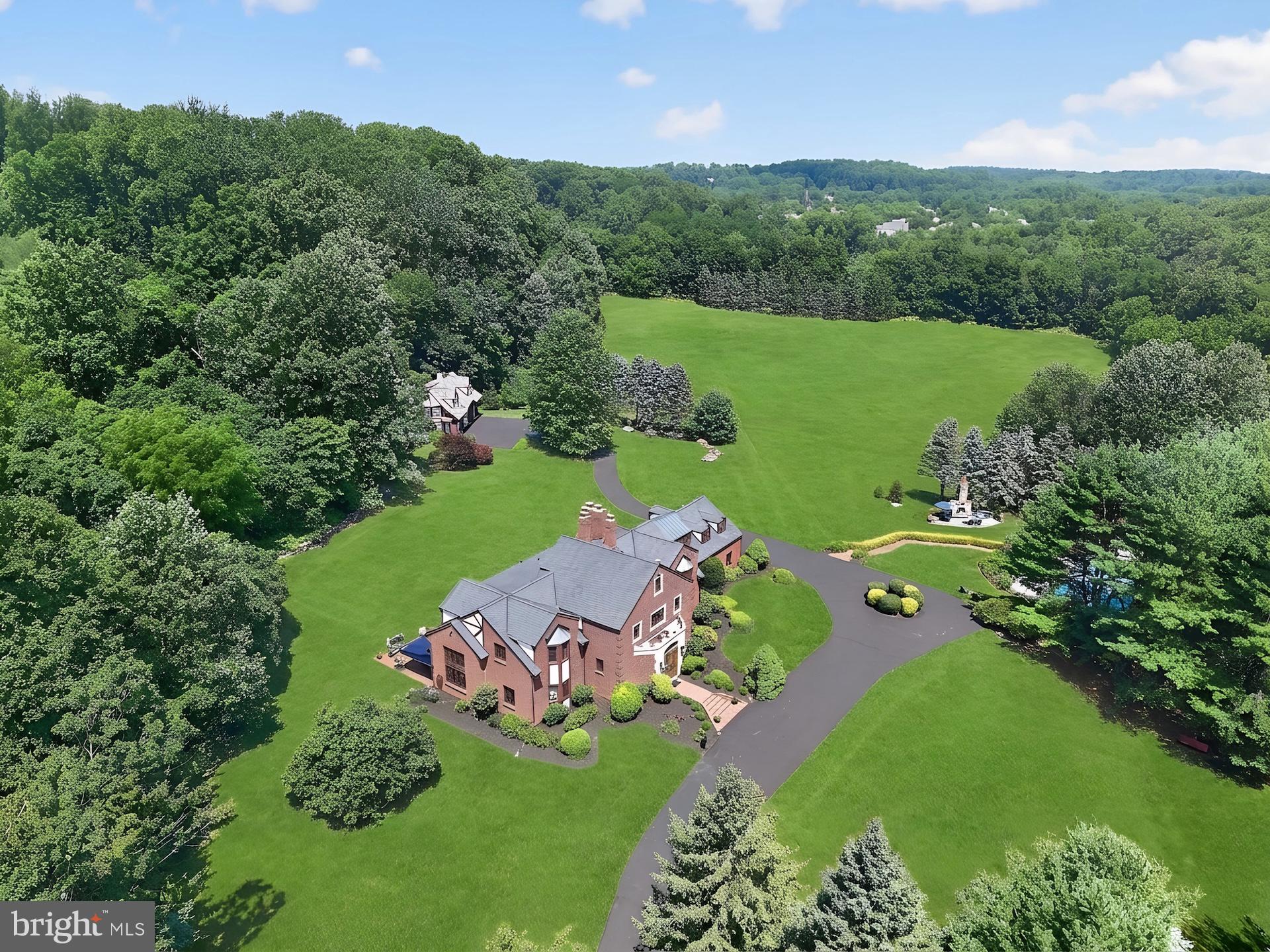 Proudly introducing Shireford, a truly extraordinary estate nestled in a coveted Chester Springs setting, where privacy, scenic beauty, and timeless Chester County character converge. Encompassing over 21 breathtaking acres across four separately deeded parcels, this remarkable property offers a rare opportunity to own a legacy estate of exceptional scale, quality, and versatility.Arrival at formal gated entry framed by magnificent shrub beds and seasonal flowers and with first sighting of main house at a prominent elevation constructed of enduring solid brick masonry, the nearly 6,000-square-foot residence showcases enduring craftsmanship, architectural distinction, and a level of quality seldom found in today’s newer homes. A grand two-story foyer adorned with lustrous marble flooring and a spectacular Schonbek crystal chandelier sets the tone for the elegance that unfolds throughout.Designed for both grand-scale entertaining and comfortable everyday living, the home features a dramatic sunlit two-story great room highlighted by custom oak millwork and a large wood-burning fireplace. The impressive two-story dining room, illuminated by a stunning Fine Art chandelier and opening to a private patio, creates an unforgettable setting for hosting family and friends. At the heart of the home, the inviting island kitchen is appointed with custom wood cabinetry and a charming wood burning fireside gathering area, seamlessly flowing into the cozy family room anchored by a handsome stone fireplace. A private first-floor ensuite provides flexible accommodations for guests or multigenerational living, while the oversized executive office/library with custom oak built-ins offers an inspiring work-from-home environment.The luxurious primary suite serves as a private retreat, featuring a beautifully appointed bath and expansive dressing area. Three additional generously sized bedrooms and a bright natural lighted office complete the upper level, including an oversized guest suite with a private bath. A convenient second-floor laundry room adds to the home’s thoughtful design.Beyond the residence, the estate’s outdoor amenities are equally impressive. Enjoy summer days by the resort-style inground pool with raised jacuzzi and one-meter competitive diving board, complemented by a fully equipped pool house with kitchen, expansive covered entertaining area, bathroom facilities, changing rooms and a stunning large separate eating area with an oversized stone Rumford wood burning fireplace, plus a built-in cooktop complete the pool setting complex.  An attached two car garage and a detached four-car garage with carriage house provides endless possibilities for guests, hobbies, collections, or future customization.With its unparalleled acreage and landscape maturity and boasting an approximate 240 large evergreens (majority in excess of 50 feet), separately deeded parcels, exceptional amenities, and premier Chester Springs location,  Shireford represents a once-in-a-generation opportunity to own one of Chester County’s most distinguished estates. A property of this caliber is truly beyond compare.