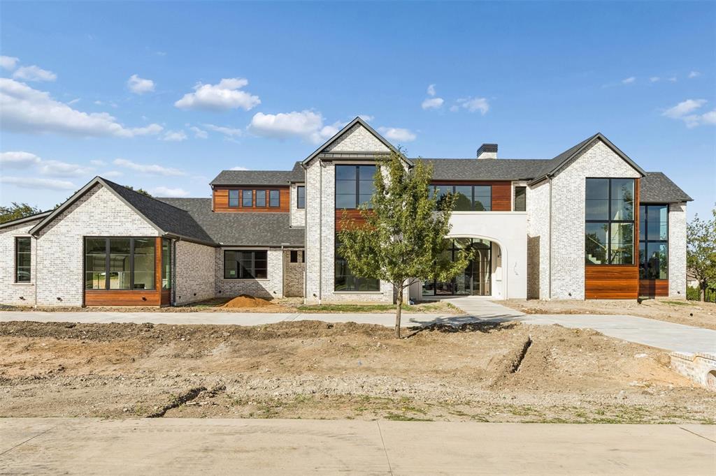 ONE MONTH FROM COMPLETION - Brand-new construction by Tim Jackson Custom Homes, one of North Texas's most respected luxury builders for three decades, on a private 1.2-acre lot in Twin Oaks, an exclusive nine-home enclave in Fairview built around a community pond, water features, and a walking trail, all within top-ranked Lovejoy ISD. The 8,091-square-foot modern traditional design combines painted brick and cast stone with standing-seam metal roof accents, a two-story entry, and tall steel-framed windows. Inside, a brick-paver foyer and floating staircase open to a great room with a gas fireplace, which connects to a kitchen finished with Sub-Zero, Wolf, and Cove appliances, custom cabinetry, and a quartzite island, where the farm sink looks out over the pool. A full prep kitchen and walk-in pantry handle the work behind the scenes. Off the main living areas, a wine room sits near the entry, and a brick-walled study offers built-ins and a spiral stair up to a private loft. The first-floor primary suite includes a sitting area set off by a see-through fireplace and a marble bath with a freestanding tub, oversized shower, dual vanities, and two walk-in closets. A guest suite sits on the main level, and upstairs, three more ensuite bedrooms, a second living room, a game room, and a carpeted media room with a wet bar. Two powder baths and separate upstairs and downstairs laundry rooms complete the plan. Out back, there's a pool with a raised spillover spa, a two-story covered loggia with motorized retractable screens, an outdoor kitchen, and a firepit, all framed by mature trees with full irrigation, fencing, and dark-sky lighting. Built with full spray-foam encapsulation, Energy Star efficiency, a Lennox Signature Series HVAC system, structured wiring, and an oversized four-car garage with epoxy floors, this is a brand-new custom estate on a private acre-plus in one of Fairview's most premier communities.
