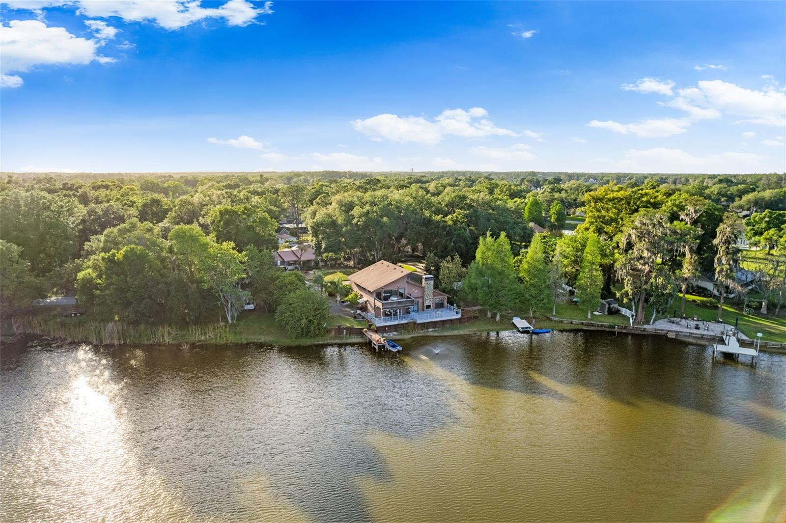 Fall in LOVE with this breathtaking LAKEFRONT residence on Lake Richard, where every moment feels like an escape and each day begins in quiet serenity. Welcome to your lake home- featuring a 3-bedroom, 2-bath MAIN HOME and a FULLY DETACHED  1-bedroom, 1-bath guest COTTAGE with a full kitchen and laundry, offering an exceptional opportunity to own two single-family homes on nearly a full acre with private waterfront living, NO HOA, and NO CDD.Each morning unfolds with stunning sunrise views shimmering across the water, setting the tone for a lifestyle defined by peace, nature, and connection. Spend your days BOATING, SKIING, or FISHING from your own BACKYARD, and your evenings unwinding in a setting that feels a world away—yet remains conveniently CLOSE to everything.The main residence is rich in warmth and character, showcasing a contemporary architecture-inspired design, soaring CATHEDRAL ceilings, and beautiful CEDAR walls that add depth and natural charm throughout. A striking double-sided wood-burning FIREPLACE seamlessly connects indoor and outdoor living, while expansive DECKS invite you to take in sweeping water views. The beautifully UPDATED KITCHEN—featuring granite countertops, soft-close cabinetry, and serene lake vistas—makes everyday living feel both elevated and effortless.Upstairs, the private primary suite is a true RETREAT, featuring your own SAUNA, a SPA-inspired bath, and an extraordinary sunroom with panoramic lake views—an ideal space for a home office, wellness studio, or peaceful reading sanctuary as the light shifts throughout the day.Adding remarkable versatility, the FULLY DETACHED guest cottage offers exceptional comfort and independence with its own bedroom, bathroom, full kitchen, and laundry—perfect for MULTIGENERATIONAL living, hosting extended guests, or generating strong rental income.Outdoors, the property transforms into a private sanctuary with a GAZEBO, FIRE PIT, FLOATING DOCK, and BOAT DOCK—all set along this serene spring-fed lake known for its natural beauty and excellent fishing. Thoughtful updates provide added peace of mind, including a main roof replacement (2018), cottage roof (2021), updated HVAC systems, foundation stabilization completed in 2020, NEW luxury vinyl FLOORING (2026) and a fully fenced backyard.This is the Florida lifestyle you’ve been dreaming of—welcome home.