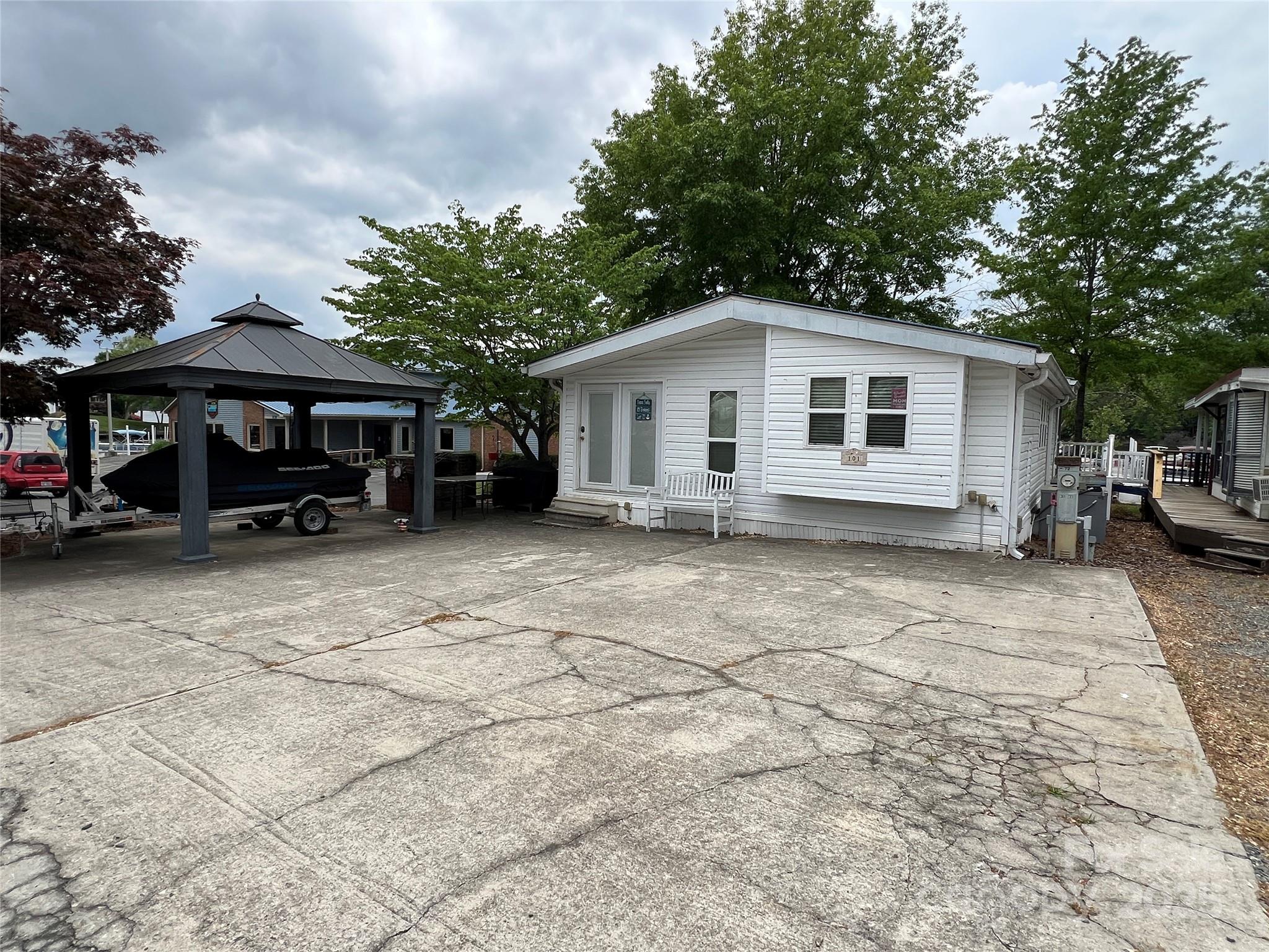 Lake Front Lake Life Awaits at this Park Model w/ addition sitting waterfront in Badin Shores Resort. Convenience is key w/ being steps from the community restaurant, sitting on the corner of the boat ramp, board walk and docks. Take the boardwalk for a short walk to access the beach area.  An "A" Lot offers lots of waterfront yard space to enjoy.  A spacious kitchen with island is open to a breakfast area and has a convenient laundry closet.  Step into the large living room w/ a wall of windows to enjoy the view and outdoors. A fireplace adds warmth and ambiance. The front room is currently being used as a bunk room / additional sleeping quarters ~ very versatile space. The bedroom has built-ins for convenience of storage. Outside, enjoy a built in wood burning/charcoal grill and gazebo street side.  Facing the water, a large covered deck is ideal for relaxing &/or entertaining and enjoying the views of the water, boats and beach area.  This home is priced to reflect the needed TLC.