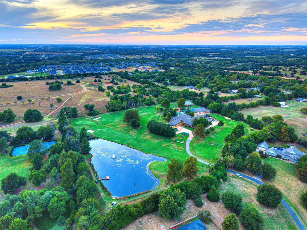 A truly exceptional offering in the heart of Edmond, this private 18-hole golf course estate combines refined craftsmanship, resort-style amenities, and an extraordinary outdoor lifestyle. Set on nearly nine acres of manicured grounds, this one-of-a-kind property features a professionally maintained golf course, stocked fishing pond, tennis and pickleball courts, and multiple outdoor entertaining spaces.

The main residence welcomes you through a custom front door into a home of elegance and warmth. The expansive living room boasts soaring ceilings, rich woodwork, and a grand stone fireplace with sweeping views of the private course and backyard retreat. The chef’s kitchen features stainless steel appliances, a large island, coffee bar, wine bar, and custom cabinetry, while the formal dining area glows beneath exquisite chandeliers.

The primary suite offers an elegant sanctuary with detailed millwork, fireplace, and private sitting area. Upstairs, a vaulted bonus room with wet bar and fireplace creates the perfect space for entertaining or relaxing. Additional highlights include a large game or exercise room, built-in cedar sauna, and a flexible upstairs bonus room that can serve as an additional bedroom or office.

Outdoors, the estate is designed for recreation and entertainment with a custom pool and hot tub, outdoor kitchen, multiple patios, and covered seating areas. A stocked pond with dock, professional pickleball and tennis court with lighting, and winding golf cart paths complete this remarkable property. The gated, tree-lined driveway leads to a private workshop and equipment storage area, with over $250,000 in professional golf course equipment and 10 golf carts negotiable.

Owning a private 18-hole golf course within Edmond city limits is virtually unheard of. More than a home, this is a lifestyle of exclusivity, recreation, and unmatched beauty—ideal for private living, corporate retreats, or the ultimate entertaining venue.