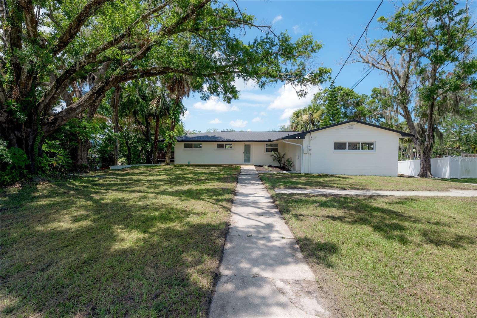 Welcome Home to your own private piece of Old Florida—nestled along the banks of the Cotee River in one of New Port Richey’s most peaceful and established neighborhoods. Set at the end of a quiet cul-de-sac and just minutes from the vibrant, historic downtown district, this beautifully renovated five-bedroom, four-and-a-half-bath home offers over 3,800 square feet of flexible living space on an oversized, oak-shaded lot spanning more than half an acre. With direct river access and a layout designed for comfort and connection, this is the ultimate setting for laid-back luxury living.

Inside, the home features a thoughtful, two-story layout with room for everyone. The main level offers two spacious bedroom suites, each with its own updated en suite bathroom. One of the suites opens directly to a large shared balcony that also connects to the main living area—a peaceful spot to take in river breezes and leafy views from above. The open living and dining areas flow easily together, creating an airy, light-filled atmosphere that’s perfect for both daily living and entertaining.

The kitchen has been completely remodeled with shaker cabinetry, sleek countertops, and stainless steel appliances, offering plenty of prep space and storage. Whether you're cooking for one or hosting the whole crew, this kitchen is equal parts beautiful and functional.

Downstairs, the home continues to impress with three additional bedrooms, two full bathrooms, and multiple flexible living spaces that can easily serve as a media room, game room, home gym, guest quarters, or even a private in-law suite. With its own separate entry and an easy flow to the backyard, the lower level is perfectly suited for multi-generational living or long-term guests.

Outside is where the lifestyle really takes over. The backyard feels more like a private park, framed by mature trees, swaying palms, and lush greenery. Spend your mornings fishing from the riverbank or your afternoons napping in a hammock under the oaks. A screened-in lanai provides a shaded, bug-free zone to relax or entertain, and there’s plenty of room to add a pool, fire pit, or garden if you choose. With a private boat launch right on the property and deep-water Gulf access just 45 minutes downstream, the only question is: what kind of boat will you keep in your backyard? There’s also covered storage for your boat or extra vehicles, giving you everything you need for a true Florida waterfront lifestyle.

This home is just a short walk to two nearby city parks and a quick drive or golf cart ride into downtown New Port Richey, where you’ll find an eclectic mix of restaurants, breweries, boutiques, and community events along the riverfront. With no HOA, an oversized lot, and a fully updated interior and exterior, this is a rare opportunity to own a piece of the Cotee River lifestyle—private, peaceful, and only getting better with time.

Come see for yourself what life on the river can really look like. This one is more than a home—it’s an experience.