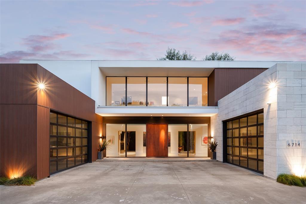 Private Architectural Modern behind gates in the heart of Preston Hollow, this striking contemporary estate blends bold architecture, refined detail, and seamless indoor-outdoor living. Designed and built by Chad Dorsey + MORE Design, the home offers a rare fusion of architectural pedigree, functionality, and integrated technology.A gated circular motor court sets the tone, with dual two-car garages—one transformed into a climate-controlled collector’s showroom with lift, workshop, and storage. A dramatic two-story glass gallery with floating pivot entry creates a light-filled architectural spine, leading to museum-finish walls, Venetian plaster, slatted wood ceilings, and three fireplaces. Oversized 24ft wide La Cantina sliding doors open for effortless indoors to outdoors entertaining and flow. A stunning four-sided 1200+ bottle glass wine gallery anchors the dining and kitchen, featuring Bulthaup cabinetry, Gaggenau appliances, and a walk-in pantry with temperature-controlled storage.The first-floor primary suite offers a limestone spa-inspired bath, walk in shower + soaking tub, dual closets with tornado room, and private glass walled executive office overlooking the manicured rear yard. Outdoors, enjoy a resort-style pool with slide and chiller, putting green, turf lawn, mosquito misting system, and a covered pavilion with outdoor kitchen, drop-down screens, cooling misting, and heaters.Upstairs includes four sophisticated ensuite bedrooms, a tv-media lounge with wet bar, fitness studio and powder bath with both living spaces connected to a tree house view terrace. Savant whole-home AV, electronic shades, WiFi 6, security, generator, elevator, walk out conditioned mechanical room, and whole-house systems complete this exceptional offering on a premier 100x160 lot.