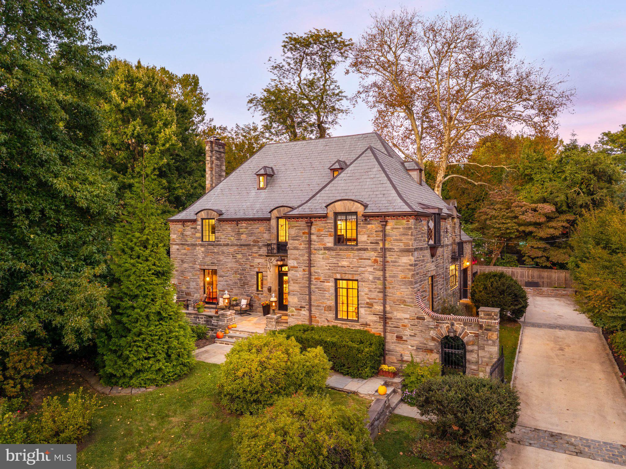 A Wynnewood gem. Welcome to 415 Penn Road, a stately stone Normandy showcasing extraordinary Old World charm, rich architectural detail alongside extensive updates and pride of ownership that is truly rare to come by. Glorious natural light, random-width hardwood floors, high ceilings and exceptional millwork are complemented by extensive improvements, including a new slate roof with copper gutters (2017), restoration and replacement of steel casement windows throughout much of the home (2023), a new boiler (2024), a new air-conditioning (2025), a rebuilt sunroom (2023, 2025), and a new rear flagstone terrace and restored front terrace (2022). All of this awaits in a wonderfully central Lower Merion location, within walking distance of the Wynnewood train station, shopping and Whole Foods.A handsome front door opens to a two-story entrance hall, where a gracious staircase features gently curved lower steps and an intricate iron railing. Elegant archways frame views into the main living spaces, creating an easy flow through the first floor. The generously sized living room is rich in character, with exposed beams resting on decorative corbels and a substantial stone fireplace mantel embellished with carved detailing. Tall windows fill the room with light, while French doors lead to a lovely sunroom with exposed stone walls and windows on multiple sides. Comprehensively rebuilt during the current ownership, the sunroom received structural enhancements, exposure of the interior stone wall, a new roof and drainage system, repointing of exterior brick and stone, and new steel windows and double doors.On the south side of the home, the dining room and kitchen are flooded with natural light. Exquisite moldings and tall windows give the dining room a refined setting for entertaining. The cheerful eat-in kitchen pairs colorful cabinetry with dark countertops, double wall ovens, a peninsula with seating and ample space for a large casual dining table. A wide window above the sink, accented by a diamond-patterned leaded-glass transom, adds another thoughtful detail. Centrally situated yet tucked into a quiet, private location, the well-sized office overlooks the rear stone terrace. A powder room completes the first floor.The light-filled staircase leads to the second floor, where the primary suite includes two walk-in closets and a spacious bath with a double vanity, tub and separate shower. Three additional bedrooms enjoy abundant sunlight; one has an en suite bath, while two share a Jack-and-Jill bath. Each offers its own charm, from French doors opening to a Juliet balcony to beautiful moldings and curved doors, with generous closet space throughout. Upstairs, the third-floor suite includes a sitting area, a large bedroom with an en suite bath and a whimsical “Harry Potter” bedroom with exposed beams. A partially finished basement offers space for a home gym and/or additional recreation space.Front and rear stone terraces make for indoor/outdoor flow, while gas lanterns cast a warm glow for evening dining and entertaining. Mature trees line the perimeter of the private, fenced yard. A concrete driveway leads to a private parking court secured by a beautiful iron gate, with access to the attached two-car garage.Additional improvements on the extensive list include: new concrete driveway (2023), re-plastering of the first and second floors (2023), restoration of the bedroom balcony’s steel double-door assembly (2023), exterior stonework repointing, gas lanterns and renovation of the third-floor bonus room (2024); replacement of the primary air-conditioning unit ( 2025); and independent air-conditioning systems for two bedrooms (2021).A commuter’s dream, this convenient setting offers walkable train access and easy connections to major roadways.