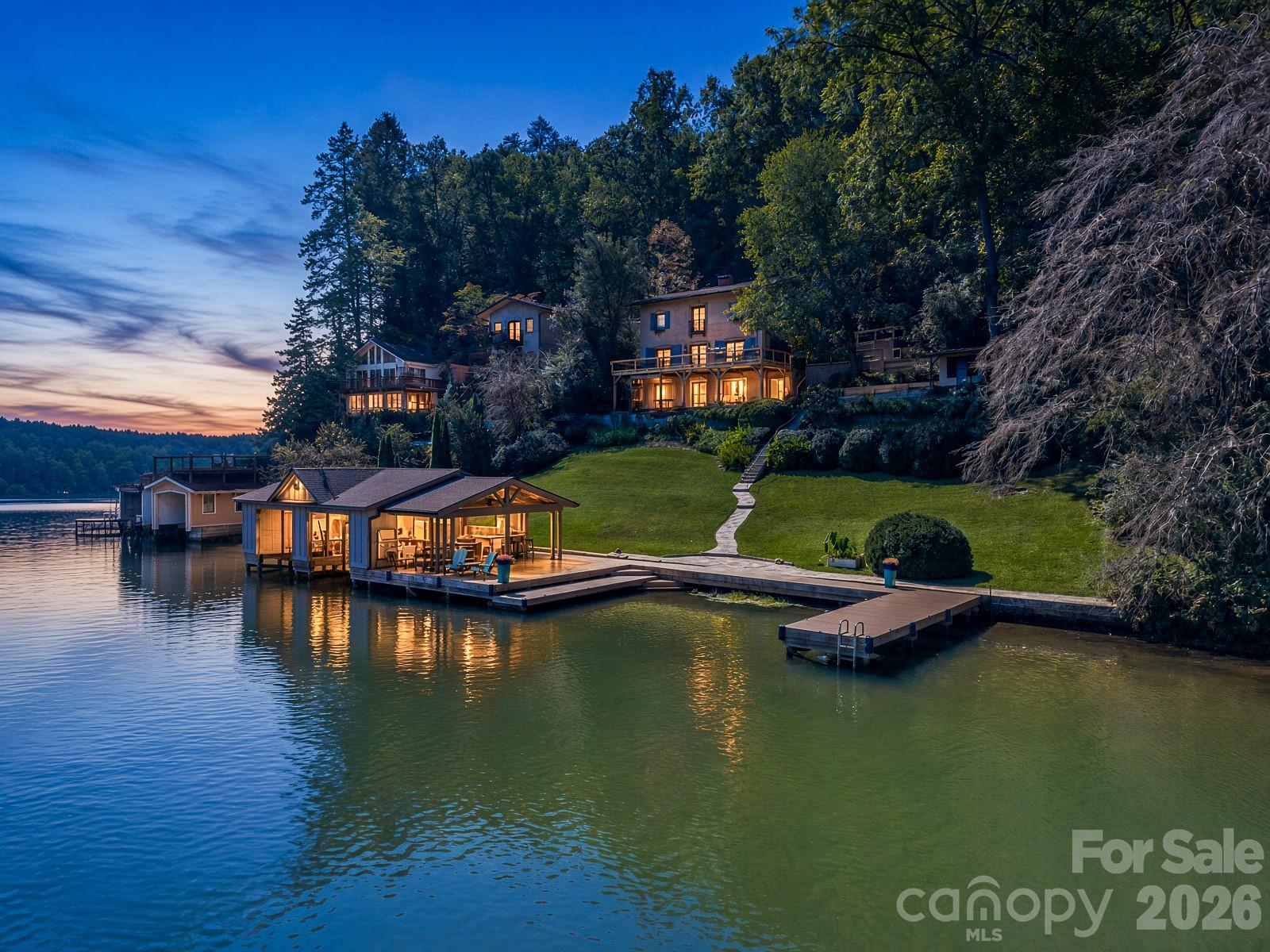 # A Legacy on the Lake. A Lifestyle Beyond Compare.Along the picturesque shores of Lake Lure, an extraordinary waterfront estate awaits—where timeless Tuscan-inspired architecture, rich history, and an exceptional lakefront lifestyle come together in a setting of remarkable beauty.Privately situated on nearly an acre, this distinctive residence offers a rare combination of expansive waterfront grounds, extraordinary boating amenities, and the unmistakable charm of a home designed to be enjoyed for generations.Originally built in 1941 as the first residence on this coveted cove, the property holds a special place in Lake Lure's history. Its enduring architectural character and inviting atmosphere create a sense of place that simply cannot be replicated.Spanning three levels and approximately 2,800 square feet, the villa blends classic elegance with modern comfort. Beautiful hardwood floors, an updated kitchen, and welcoming living spaces provide the perfect backdrop for both intimate gatherings and gracious entertaining. Three ensuite bedrooms offer private accommodations, while a fourth bedroom and two additional half baths provide flexibility for family and guests.Beyond the main residence, a detached garage is complemented by a dedicated artist's studio above—a distinctive and inspiring space for creative pursuits, personal reflection, or simply enjoying a peaceful retreat. Generous parking, an exceptional luxury along this stretch of Lake Lure shoreline, makes welcoming family and friends effortless.Yet it is outdoors where this remarkable estate truly distinguishes itself.A sweeping lawn gently descends toward the water, framed by mature trees and established landscaping. A brand-new deck offers an inviting vantage point from which to enjoy the changing colors of the lake and surrounding landscape.At the water's edge, an extraordinary collection of boating and entertaining amenities transforms everyday lake living into something exceptional. A double boathouse, two additional boat slips, and room to accommodate two more boats offer remarkable flexibility for life on the water.The waterfront bar and covered entertaining pavilion create a destination all their own—a place for leisurely afternoons, sunset cocktails, and unforgettable evenings surrounded by the beauty of Lake Lure.As twilight settles over the cove and warm lights begin to shimmer across the water, the estate reveals its most enchanting character.**This is more than a waterfront home. It is a place to gather, to celebrate, to create traditions, and to become part of a legacy that began more than eight decades ago.**A rare opportunity to own an extraordinary piece of Lake Lure's waterfront heritage.
