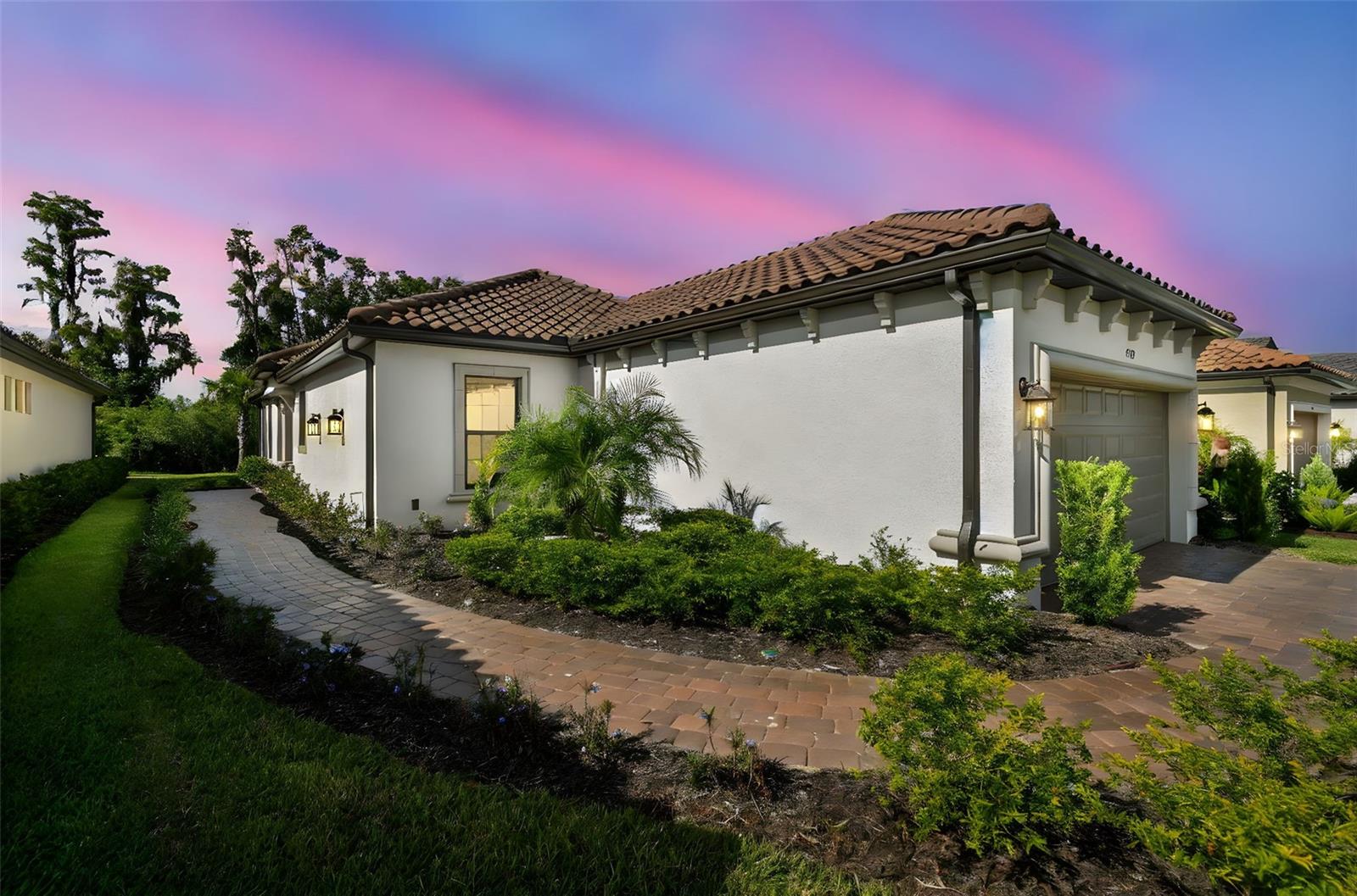 Why wait to build when you can have it all now with this beautifully upgraded Roma model home in Esplanade at Wiregrass. This 2-bedroom, 2-bath, plus office/flex, 2-car, 1,694 SF home has an extended garage on a beautiful conservation lot is all you have been looking for in a home. The kitchen features custom cabinets, quartz counters, upgraded stainless steel Cafe appliances, pantry, and a deep SS sink. The kitchen has ample counterspace for entertaining overlooking an inviting great room with tray ceiling, and crown molding with a large sliding glass door leading to the lanai.  The expanded primary suite features a tray ceiling, walk-in closets, quartz counter, dual sinks and a large shower. A large dining room with tray ceiling has room for an oversized table.  The extended screened lanai has pavers, pre-plumbed for outdoor kitchen and a great view of serene conservation. The upgrades and features of this home include, but are not limited to, an office with French doors, luxury large format vinyl floor throughout, 8’ doors, tray ceilings, extensive crown molding, laundry room with upper and lower cabinets, sprinkler system using recycled water, upgraded garage door opener, a water softener loop and a unique lot with a pond to the front of the home and conservation to the rear.
Esplanade of Wiregrass Ranch is a 55+ community that has a luxurious upscale club house with full-time lifestyle and fitness directors. The Venue includes a resort style pool, hot tub, cabanas, dog park, state-of-the-art 24-hour fitness center, billiard/card room, and spa room. For active outdoor entertainment there is a firepit, tennis, pickleball, bocci, and a large meeting/gathering area.  Esplanade also includes worry free yard maintenance, reclaimed water and Spectrum TV and internet package included in fees. This home is located only minutes from shopping, I-75, hospitals, restaurants, recreation, and entertainment. Come see for yourself this exquisite residence, sit down, relax, call it home, and live the lifestyle! Please see Matterport 3D tour.