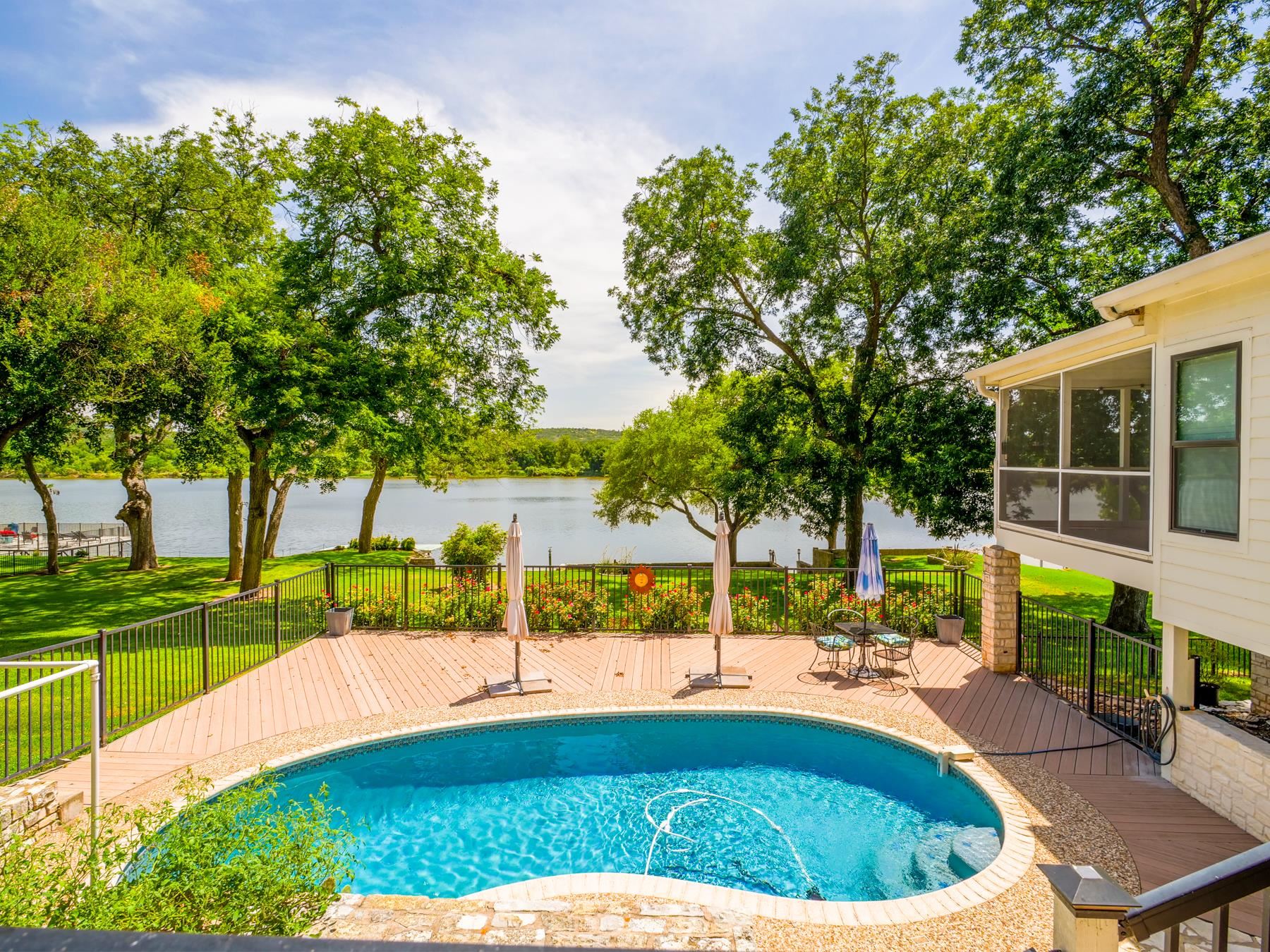 90' of gorgeous open Lake Marble Falls waterfront located in the Gated Community of Meadowlakes.  Incredible open water views with large mature trees.  3 full bedrooms, 5 bathrooms, and with one half bathroom.  Each bedroom has its own bathroom.  Large master suite is equipped with a huge master bath and enormous walk in master closet.  Master also has access to screened in deck with water views.  As you enter the home you are welcomed by a huge open living area.  There is a dining room/bonus room that is currently being used at an exercise room.  Kitchen area is very spacious and is equipped with stainless steel appliances, granite counter tops, tons of cabinetry, and a large pantry.  It also connects to an additional second living area.  There are two separate office/4th or 5th bedroom areas.  Enjoy the spectacular water views from the separate enclosed heated and cooled covered bonus room.  There is an additional outside covered deck that overlooks the swimming pool.  In addition to the two-car garage there is a heated and cooled workshop/storage room.  The swimming pool area is complemented by an adjacent party room, additional storage, and a private bedroom with a separate bathroom.  This home has so many features.  Must see to appreciate all the amenities this home has to offer.