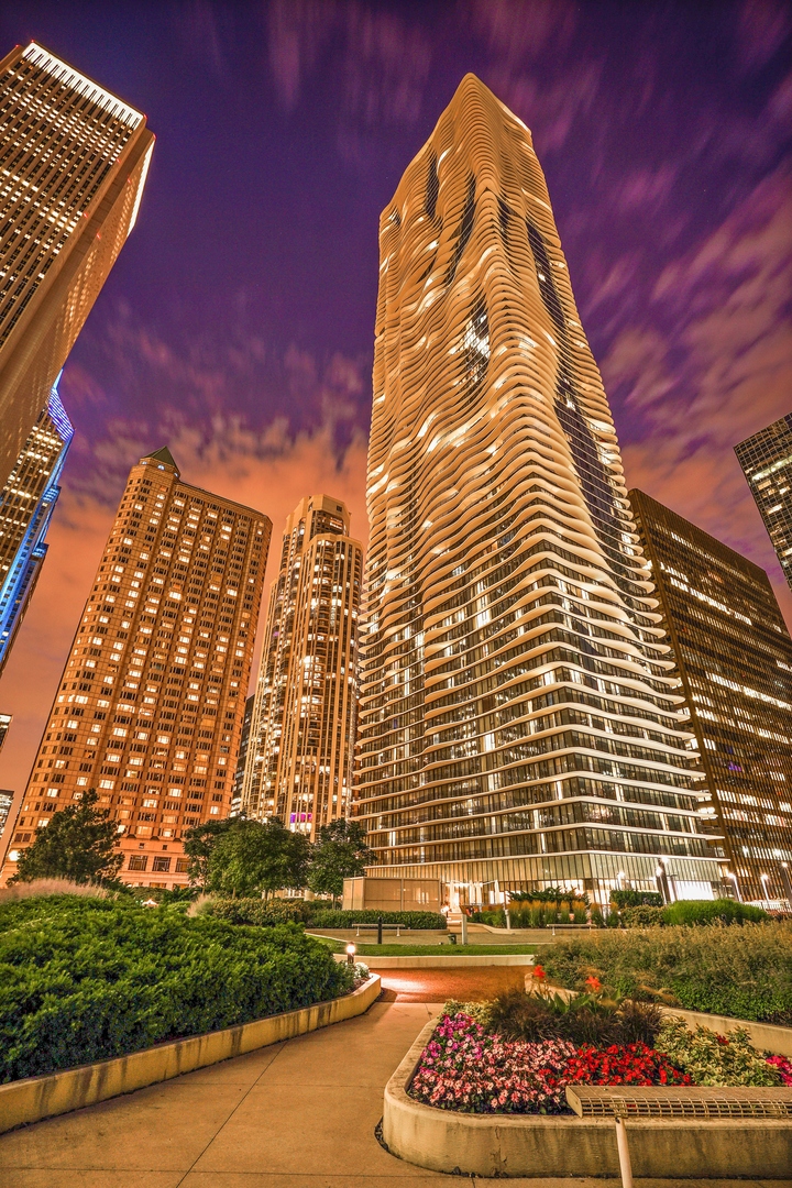 Sitting 62 floors above the city in Aqua, this oversized one-bedroom plus den offers panoramic north, east, and west views with a massive 37-by-7-foot private balcony.    The layout includes 1,210 square feet of well-designed space with floor-to-ceiling windows, walnut hardwood floors, solid-core wood doors, and updated lighting throughout. The den works well as a home office or guest space.    The kitchen features 42-inch Snaidero Italian cabinetry and stainless appliances. The primary suite includes a walk-in closet with custom built-ins, and the bathroom has been extensively updated.    Additional highlights include in-unit laundry and a large storage closet.    Aqua offers full-service living with indoor and outdoor pools, hot tubs, a fitness center, Pilates studio, theater, herb garden, business center, and 24-hour door staff. Monthly assessments include nearly all utilities and services. Parking is available for rent.    Located in Lakeshore East near the Riverwalk, Millennium Park, and the lakefront. Easy access to dining, transit, and downtown offices. A rare opportunity to live this high in the sky.