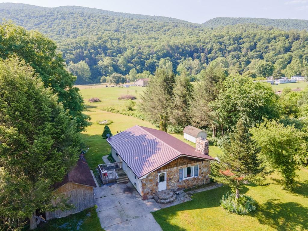 Enjoy the best of Southwest Virginia living in this charming one-level home nestled in a quiet neighborhood with breathtaking mountain views in every direction. Offering 3 bedrooms and 1.5 bathrooms, this property combines comfortable living, usable outdoor space, and an unbeatable location for both everyday life and weekend adventures. Situated on mostly flat, cleared land, the property provides ample room for gardening, recreation, pets, or future projects. A  deck just off the kitchen creates the perfect setting for grilling, entertaining, or simply relaxing while taking in the stunning mountain scenery. The private backyard offers a peaceful retreat surrounded by nature. For those needing extra space, this property delivers with multiple outbuildings for storage and a sizable detached garage/workshop that is ideal for hobbies, equipment or a vehicle. Private well and septic add to the property's self-sufficient appeal. Outdoor enthusiasts will appreciate the close proximity to the renowned Appalachian Trail and the famous Back of the Dragon, offering endless opportunities for hiking, sightseeing, and scenic rides. Conveniently located just 30 minutes from Wytheville and 30 minutes from Bluefield, you'll enjoy peaceful country living while remaining within easy reach of shopping, dining, healthcare, and interstate access via I-77.