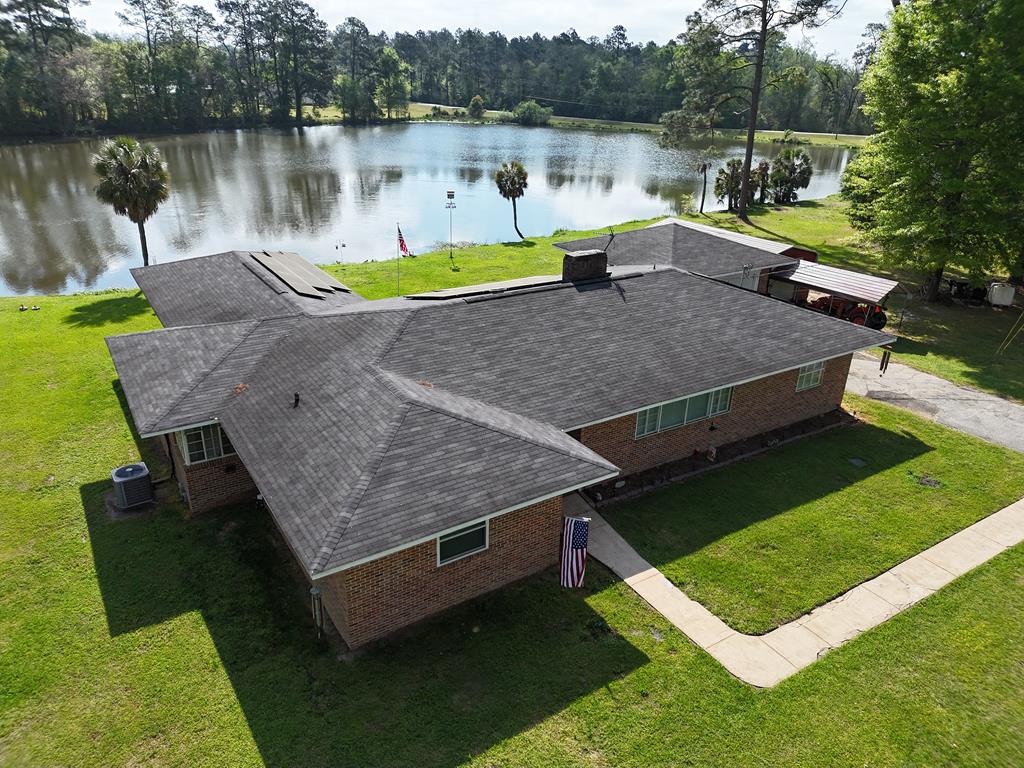 If you have been looking for the PERFECT home on the water, look no further than this hidden gem on Ells Creek Dr., Meigs, GA! This truly unique 3BR/2Bath home is 2,908 sq.ft. of wonderful open living space. The huge living room features big open windows and lots of room for furniture and loved ones coming to visit. The kitchen (appliances included) and dining area are perfect for meals big and small, and there is also a formal dining room for guests. There is a big game room with sliding glass door, a custom pantry, a huge primary suite with office and bathroom, two other big bedrooms, and a nice entrance foyer, all updated with recent renovations to the house. The updates to this home are unbelievable! New water heater, new roof in 2018, new windows, updated fuse box, cleaned vents and improved HVAC in 2025. 39 solar panels were installed in 2021, and enhanced 240 hookups have been added. This is a smoke-free home and sold as-is. Outside, you will LOVE the covered patio and fenced area overlooking the beautiful 14-acre pond. There is also a fenced 50'x31' garden area, fruit and pecan trees, utility shed, 2-car garage and MORE! Call your favorite agent TODAY for a closer look at this magnificent property! Click here for a virtual tour: https://my.matterport.com/show/?m=52Ab8daLoNp&mls=1