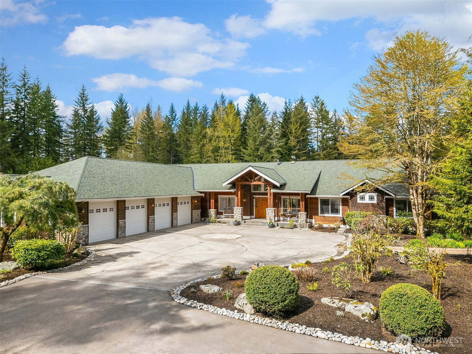 Set on 20 private acres with a gated entry, this custom rambler in the coveted Tolt Highlands offers a rare blend of seclusion and craftsmanship. Approximately 4.33 acres are cleared, level, and fully fenced around the home and shop, creating exceptional usable space for gardens, recreation, or hobby farming. Flat and sun-drenched, the property includes 1.25 miles of trails winding through pasture, fruit trees, and mature woodlands, offering a peaceful connection to the surrounding landscape. Inside, an open floorplan with 9ft+ ceilings anchors the home. The cook’s kitchen pairs slab granite counters and cherry cabinetry with hickory floors and high-end appliances. A vaulted family room flows naturally from the kitchen, centered by a river rock fireplace and bar. The primary suite is its own retreat, complete with a fireplace, walk-in closet, and spa-inspired five-piece bath. Outbuildings match the scale of the land, including a detached 40x60 ft shop with two livestock stalls, heated tack room, and secure covered storage, along with a 24x36 ft high-bay carport suited for RV or equipment. An attached four-car garage, newer roofs on the home, shop, and well house, Starlink high-speed internet, and generator wiring complete a property designed for flexibility and self-reliance. Minutes to Carnation and convenient to Redmond, Duvall, Sammamish, and the greater Eastside, this is a rare Tolt Highlands offering where privacy, functionality, and the NW landscape come together.