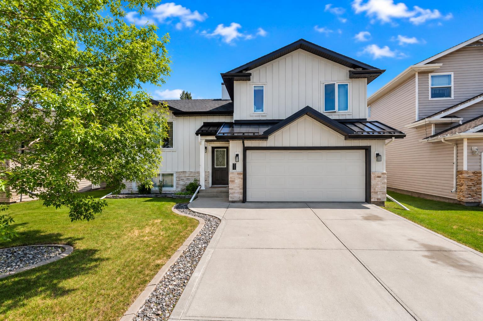 EXTENSIVELY RENOVATED INSIDE & OUT | 2 PRIMARY SUITES | 2024 ROOF, HARDIE BOARD SIDING & STONEWORK ~ This beautifully renovated 4-level split offers major interior and exterior updates with a flexible layout that works especially well for multi-generational living, extended family, guests, older children, or buyers wanting extra separation and privacy. With TWO primary-style suites, multiple living areas, and substantial renovations already completed, this home offers a level of function most homes in this range do not. ~ The main level features a spacious tiled entry, vaulted ceilings with decorative beams, updated laminate flooring, and a stunning renovated kitchen with two-tone cabinetry, crown moulding, quartz countertops, full tile backsplash, wall pantry with pull-outs, large island, and a NEWER induction stove and hood fan. The dining area offers direct access to the deck, creating an easy flow for everyday living and entertaining. ~ Upstairs offers 3 bedrooms, including the original primary bedroom with feature wall, double closets, and 4-piece ensuite, plus two additional bedrooms and a 4-piece bathroom. This level also features newer carpet, trim, paint, and bathroom updates. ~ The third level adds excellent everyday living space with a comfortable family room, laminate flooring, gas fireplace, and ground-level access to the backyard. This gives the home separation between living areas without losing connection to the yard. ~ The fourth/lower level is where the home truly stands apart, offering a second primary-style suite with large windows, custom shelving and bed frame, walk-in closet, and an impressive ensuite with dual vanities, a large tile and glass shower, and heated floors. A storage/wine room adds excellent flexibility, with additional storage available in the crawl space. ~ Outside, the yard is nicely landscaped with concrete curbing, a firepit area, deck, and garden shed with power. ~ Major updates include the deck and hot water tank in 2019, lower level redevelopment in 2020, upper bedroom/bathroom/trim/paint updates in 2023, full kitchen/living/dining/entry renovation plus Hardie Board siding, exterior stonework, and roof in 2024, carpet replacement in 2025, and the NEWER induction stove and hood fan. A move-in ready home with substantial renovation work already completed and a flexible layout most homes simply do not offer.