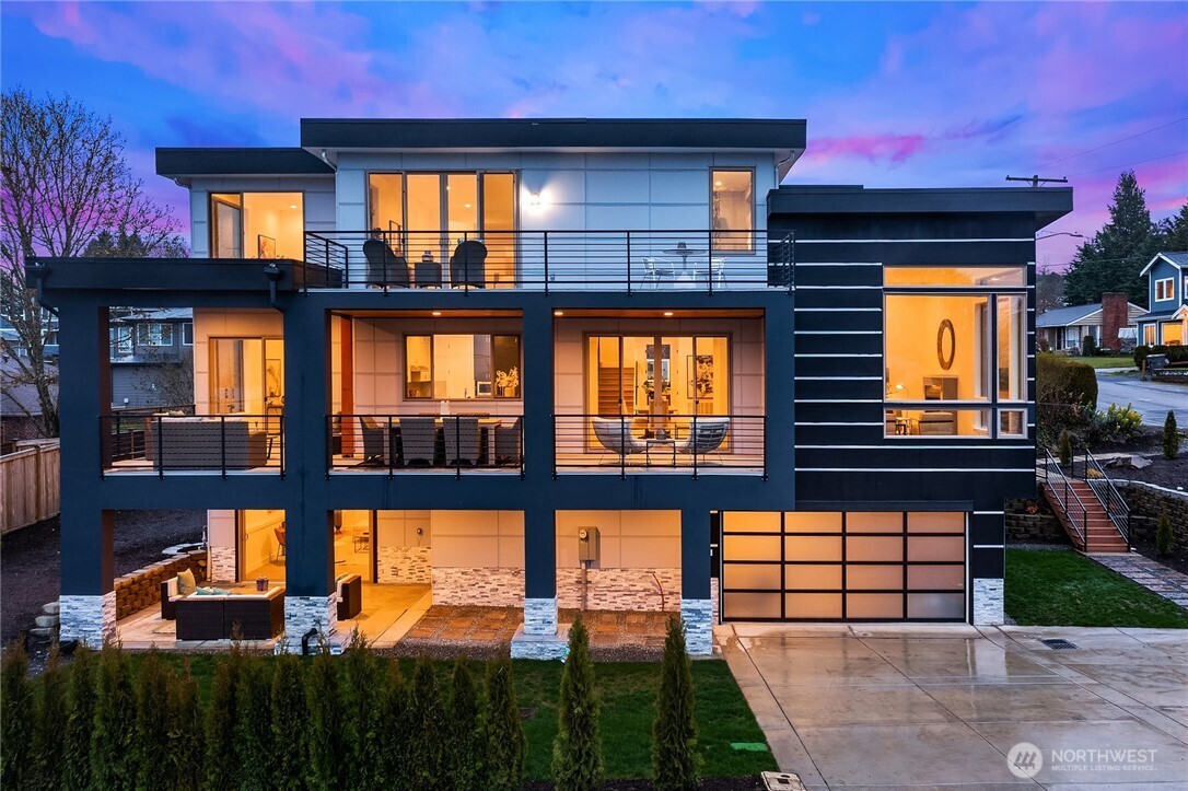 One of Kennydale's premier modern view homes—offering Lake Washington views, multiple ensuite bedrooms, a true entertainer's layout, and the convenience of Bellevue and Seattle just minutes away.Thoughtfully designed 5-bedroom, 5.5-bath residence offers flexibility, comfort, and an ideal layout for modern living, featuring a desirable main-floor bedroom suite, dedicated home office, and separate flex space perfect for a playroom, study area, sitting room, or additional workspace. The main floor features open-concept living and dining areas with soaring ceilings, abundant natural light, and access to a wraparound view deck. The kitchen centers around a large island and flows effortlessly into the living spaces. Upstairs, the primary suite enjoys a private balcony with lake and city views, plus a spacious bath and walk-in closet. Two additional ensuite bedrooms, a versatile loft, and upper-level laundry complete the floor. The daylight basement offers a media room, game room, full bath, laundry area, guest accommodations, and flexible space for a gym, hobby room, or extended living. Sliding doors open to a covered patio. Additional features include air conditioning and a 3-car tandem garage. Conveniently located minutes from I-405, Lake Washington parks and boat launch, The Landing, Bellevue, Boeing, Sea-Tac Airport, and downtown Seattle. A rare opportunity to own a spacious view home in one of Renton's most desirable neighborhoods.