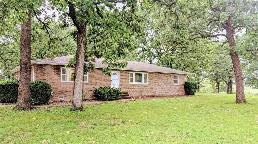 Country living at its best! Nestled on 40 acres of gently rolling pastureland, this charming, well-built all-brick home offers peace, functionality, and rural beauty in one perfect package. Inside, this 1,560 sq ft residence boasts a bright and inviting living room with large picture windows and a cozy wood-burning stove. While the stove warms the entire home, central heating and air provide modern comfort year-round. The kitchen features classic wood cabinetry and opens to a spacious dining area—easily convertible into a third bedroom if desired. The attached oversized 2-car garage provides extra room for parking, storage, or workshop space. A deep crawlspace with a concrete floor adds storage options and offers protection during storms. Outside, the property is ready for livestock or farming operations. Improvements include a 36x25 lean-to shed for equipment and a 48x120 livestock barn (built in 2019) with electricity, water, and two 12-ton grain bins—perfect for goats, sheep, or other animals. A functional paddock system is already in place, and a roping arena (which can double as a livestock pen) sits just north of the barn. With two ponds, a wooded corner for winter cover, and nearly full fencing, this property is ready to go. Plus, fiber internet access ensures you stay connected while living the rural dream. Located just 7 miles from El Dorado Springs and 15 miles from beautiful Stockton Lake, this property offers the best of country life, with all the amenities close at hand.